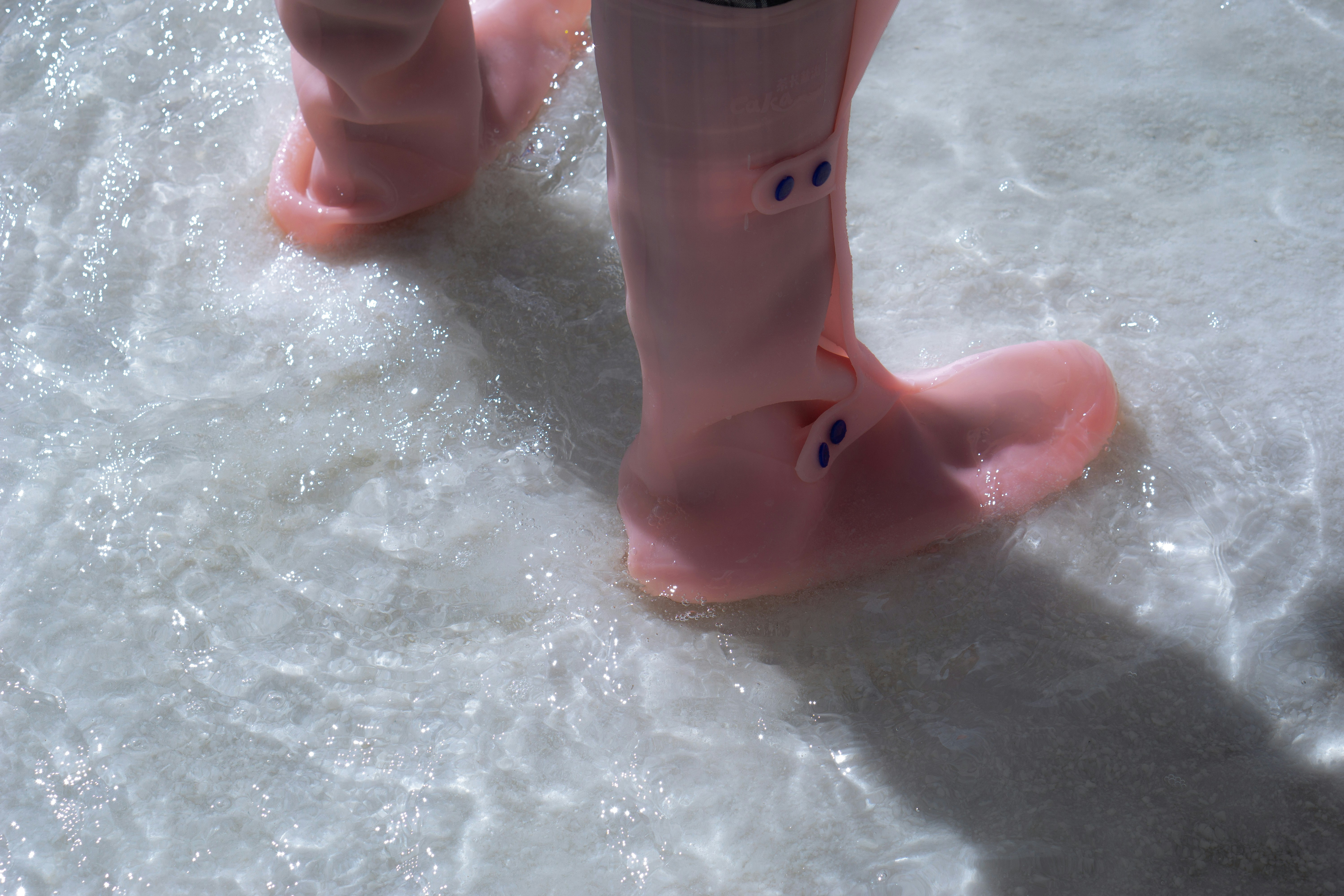 Pink boots walking through shallow water