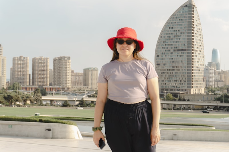 Mujer estilosa con sombrero rojo en la ciudad