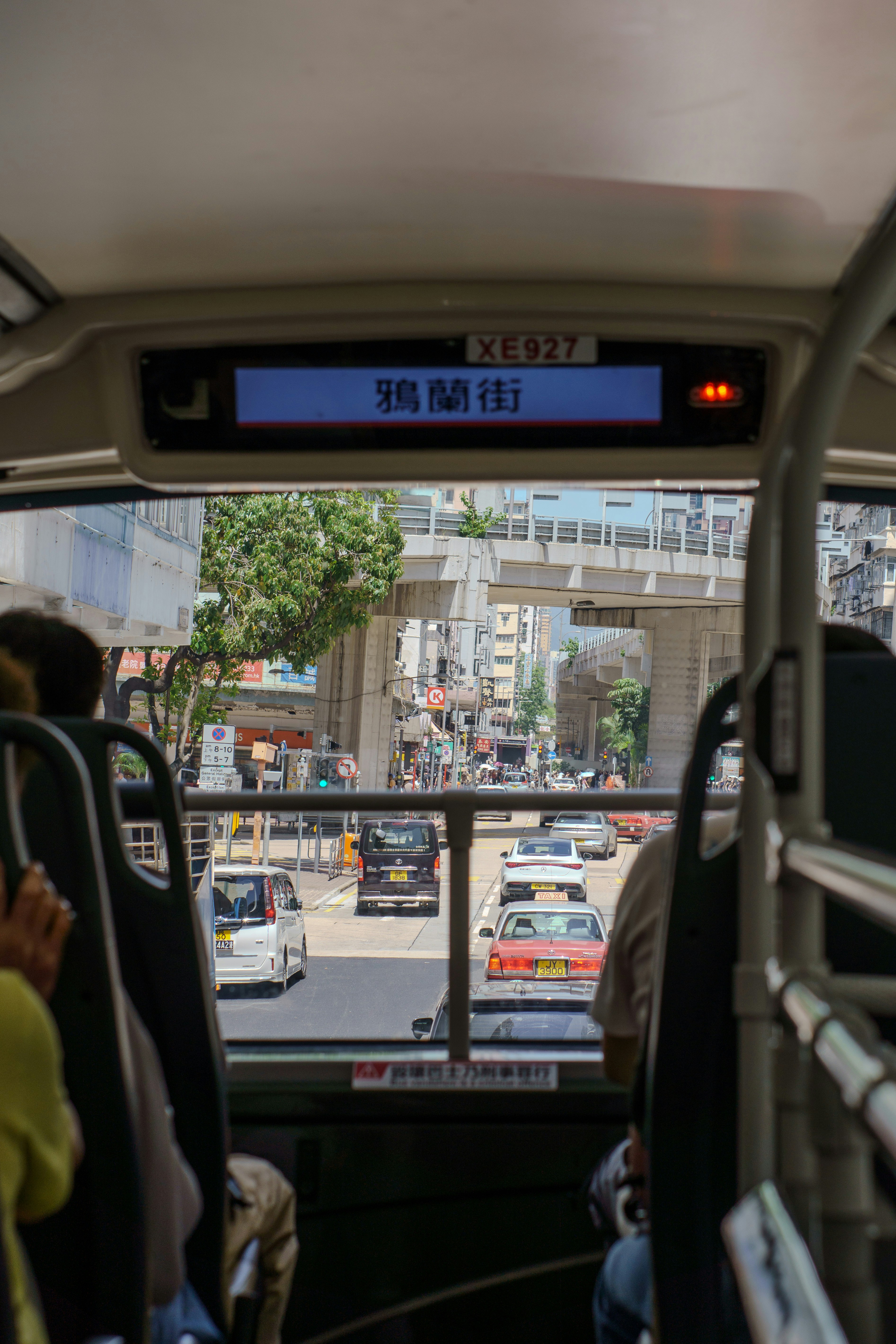 How to Navigate Public Transportation in a New City Like a Local – View from inside a bus looking out at city street.