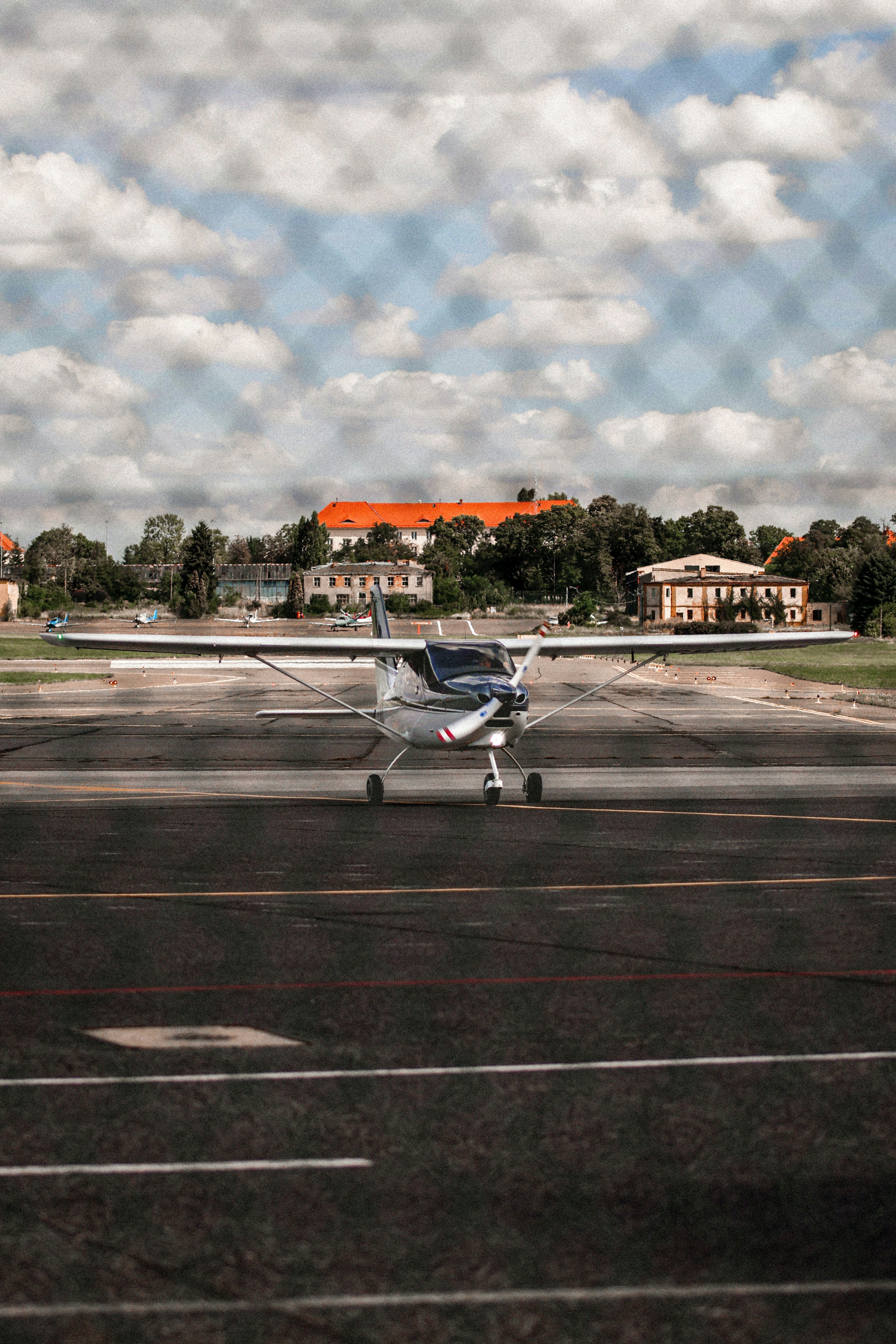 Piccolo aeroplano sull'asfalto dietro una recinzione