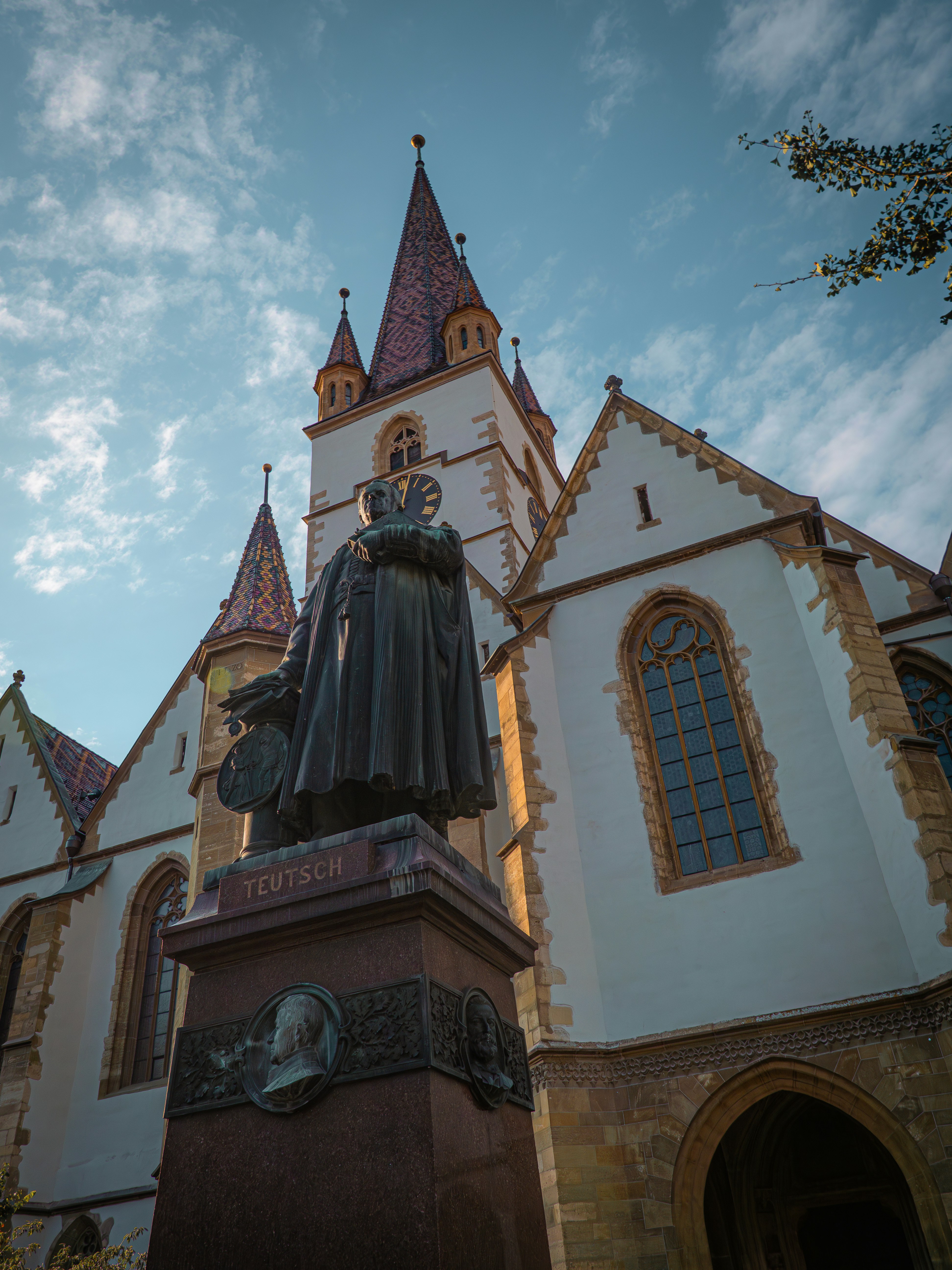 Estatua frente a una iglesia histórica con cielo azul