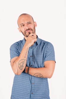 Man with beard thinking with hand on chin.