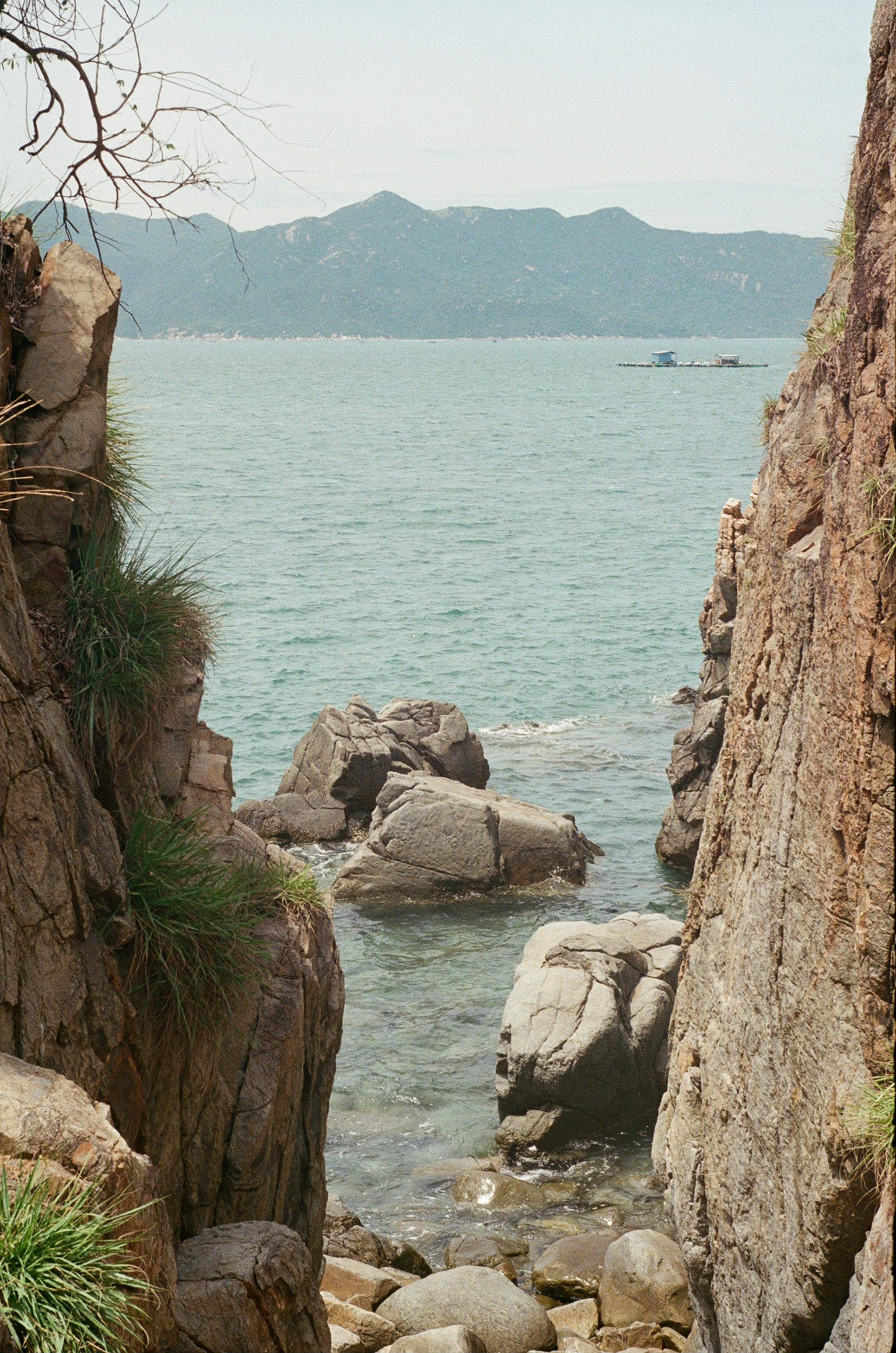 Rocky coastline with calm ocean and distant mountains photo – Free ...