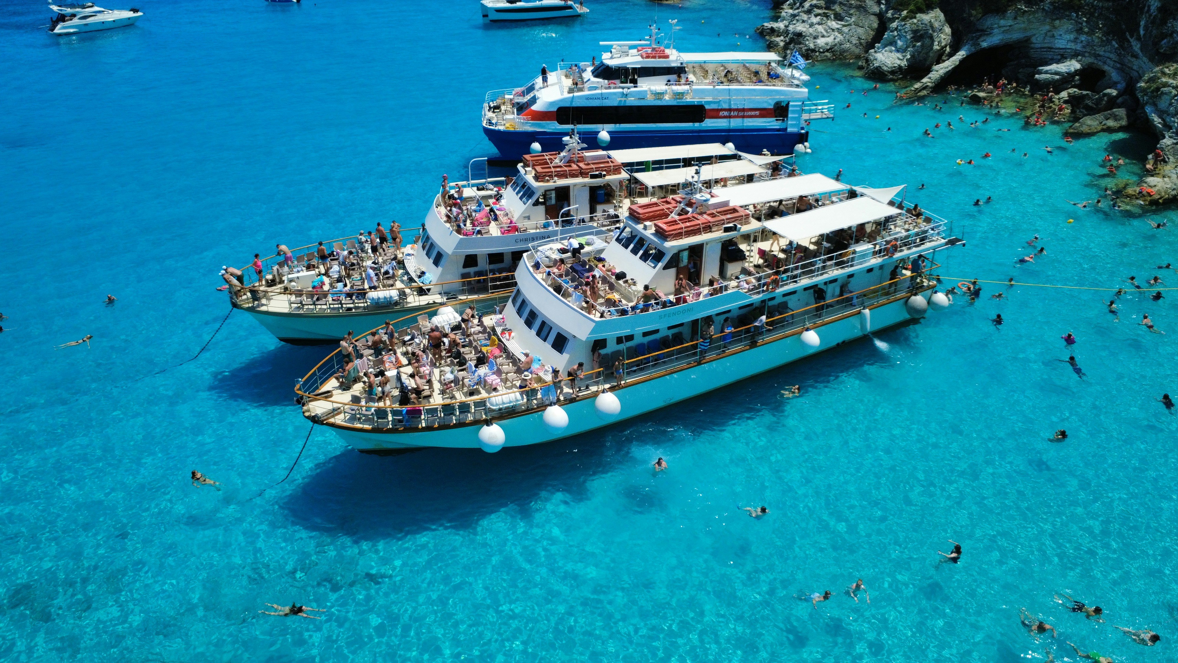 Several boats docked in clear turquoise water