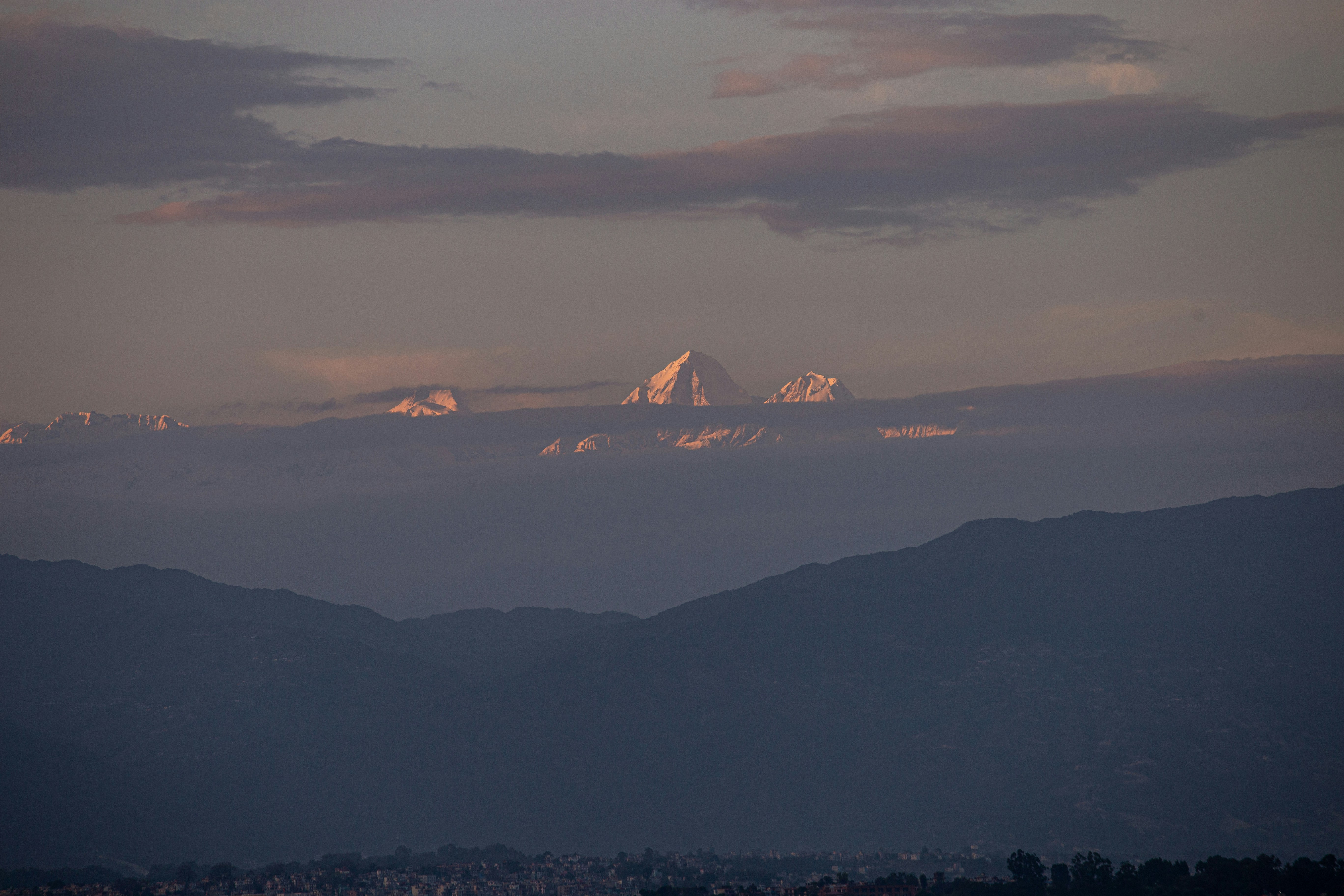 Distant mountains veiled in soft clouds at dusk