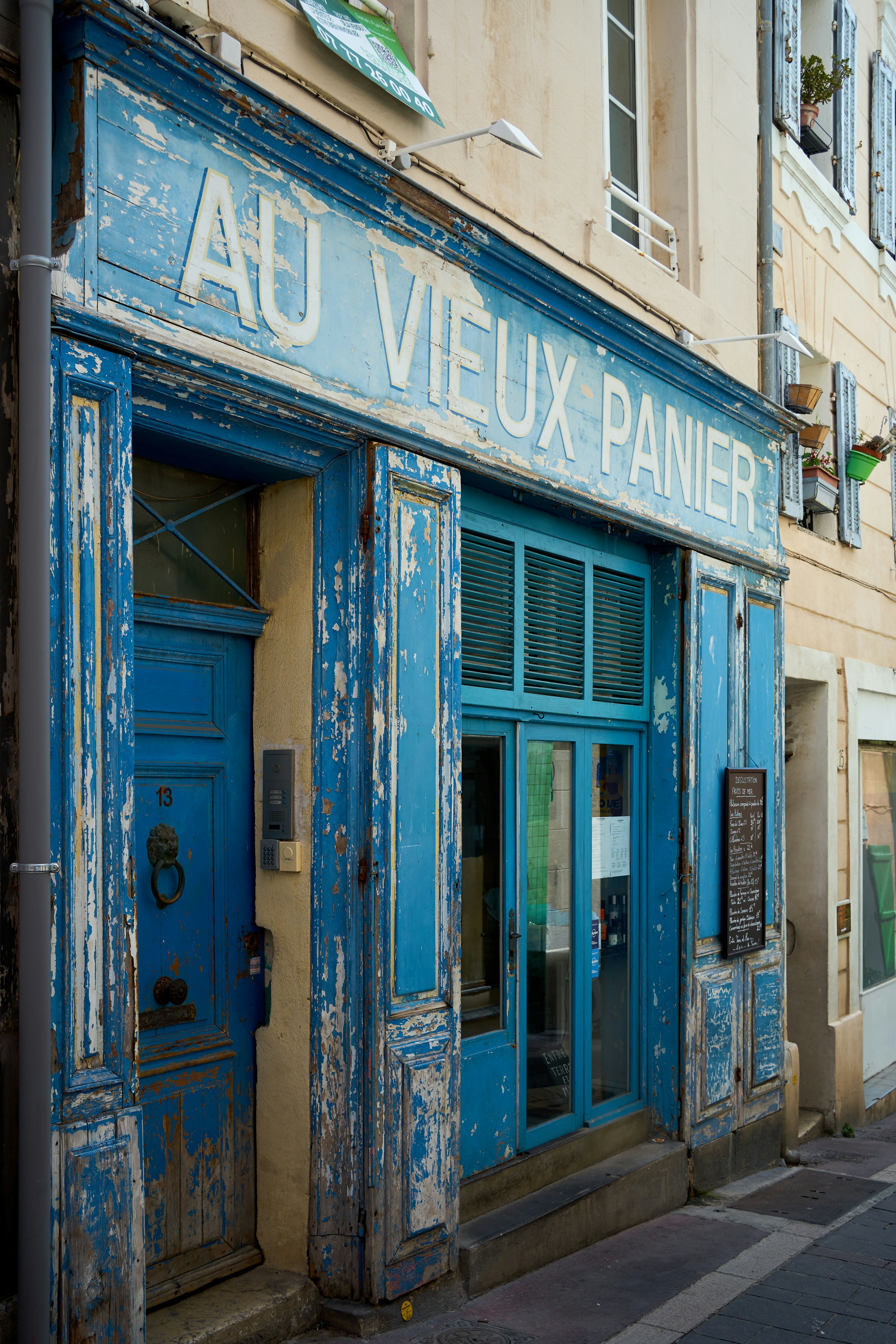 A weathered blue storefront with peeling paint