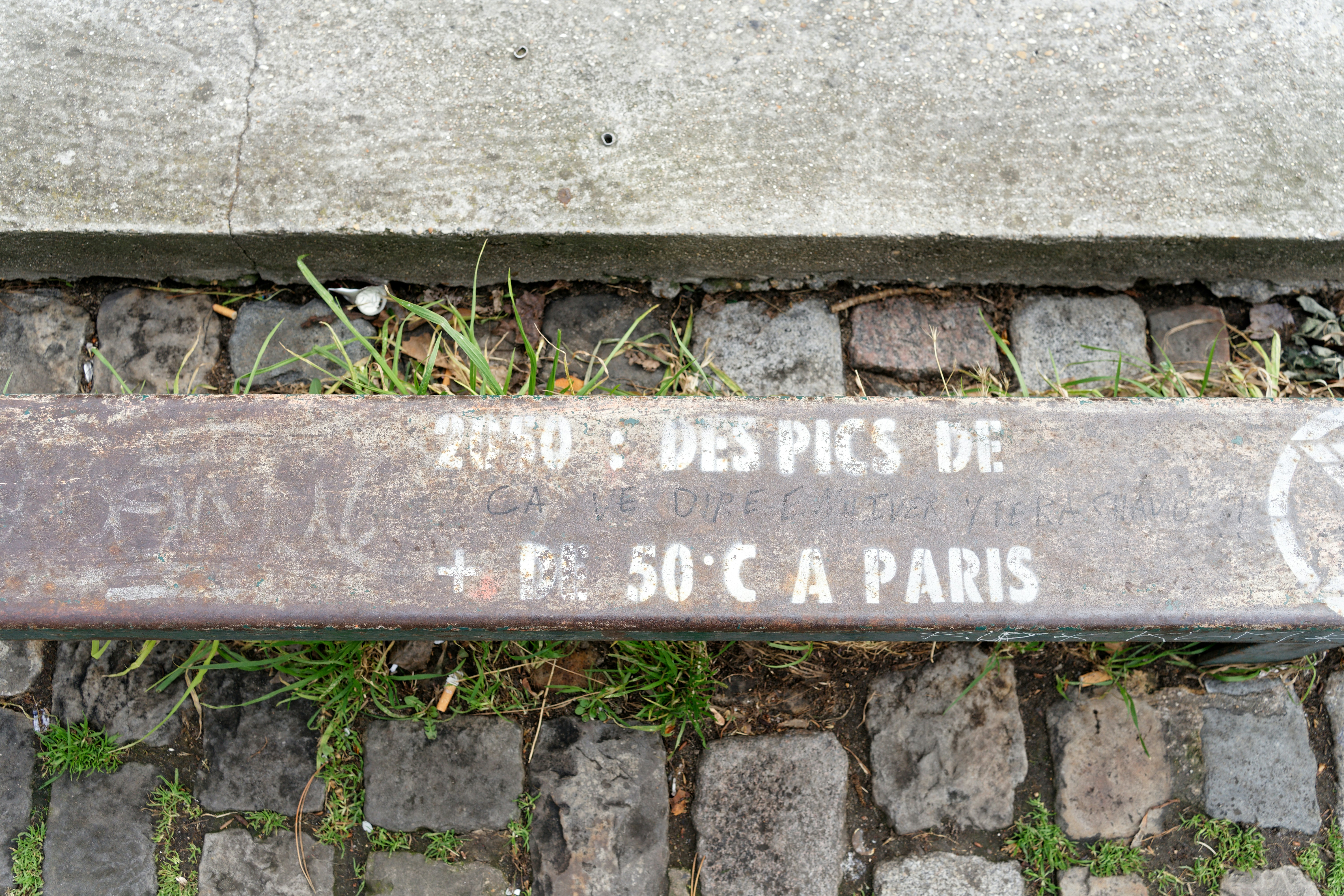 A cafe paris sign glows brightly in the dusk.