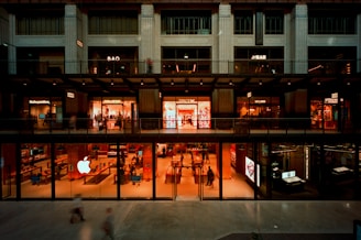 Modern building with glowing storefronts at dusk