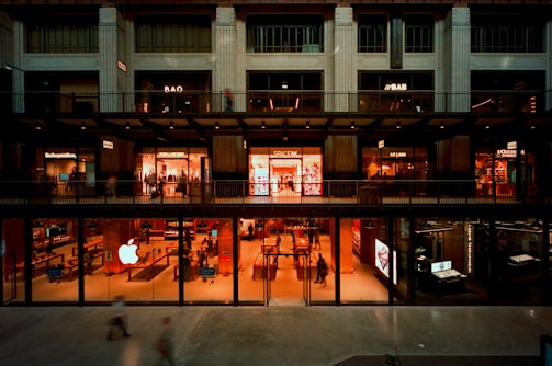 Modern building with glowing storefronts at dusk