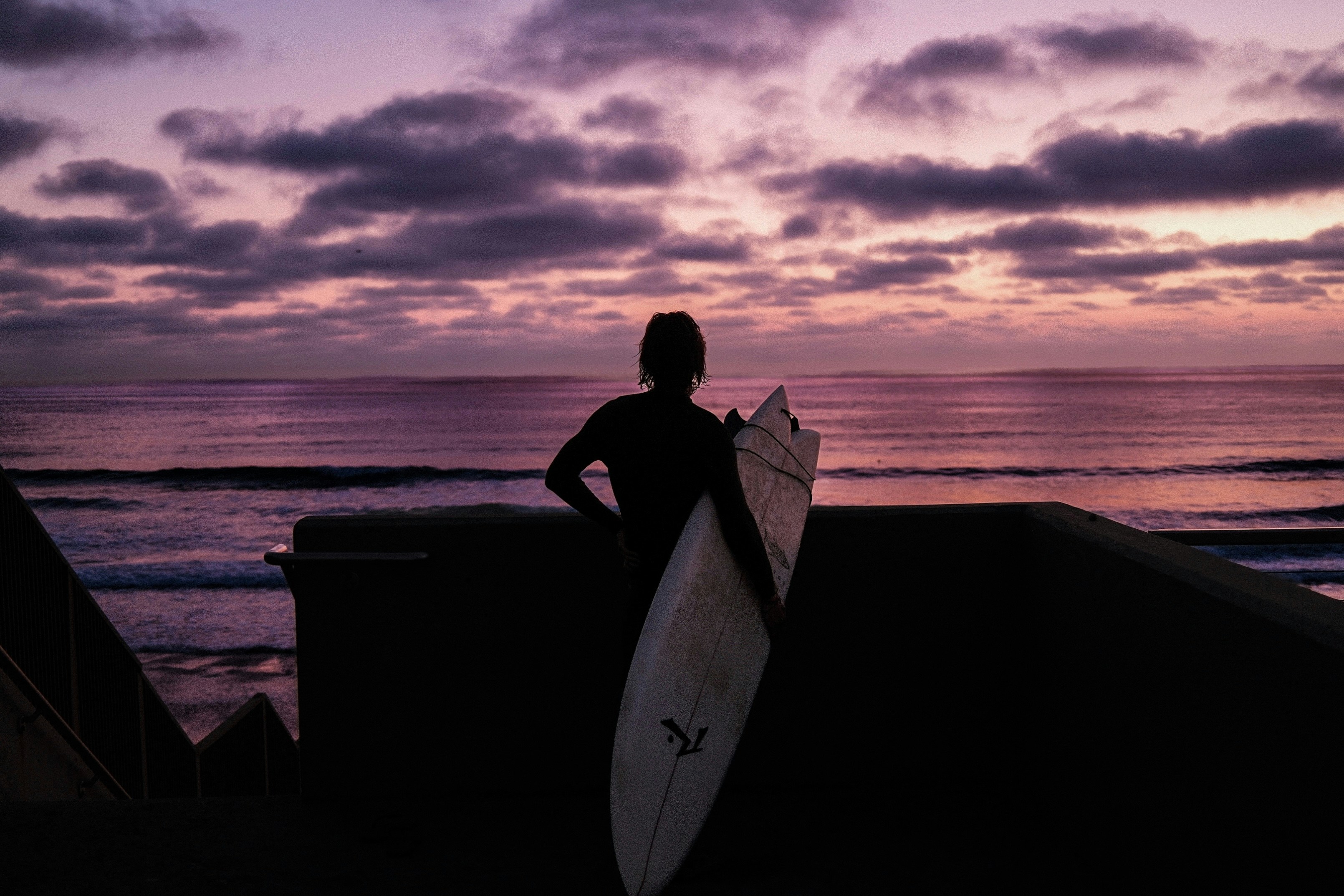 Surfer watching the sunset over the ocean