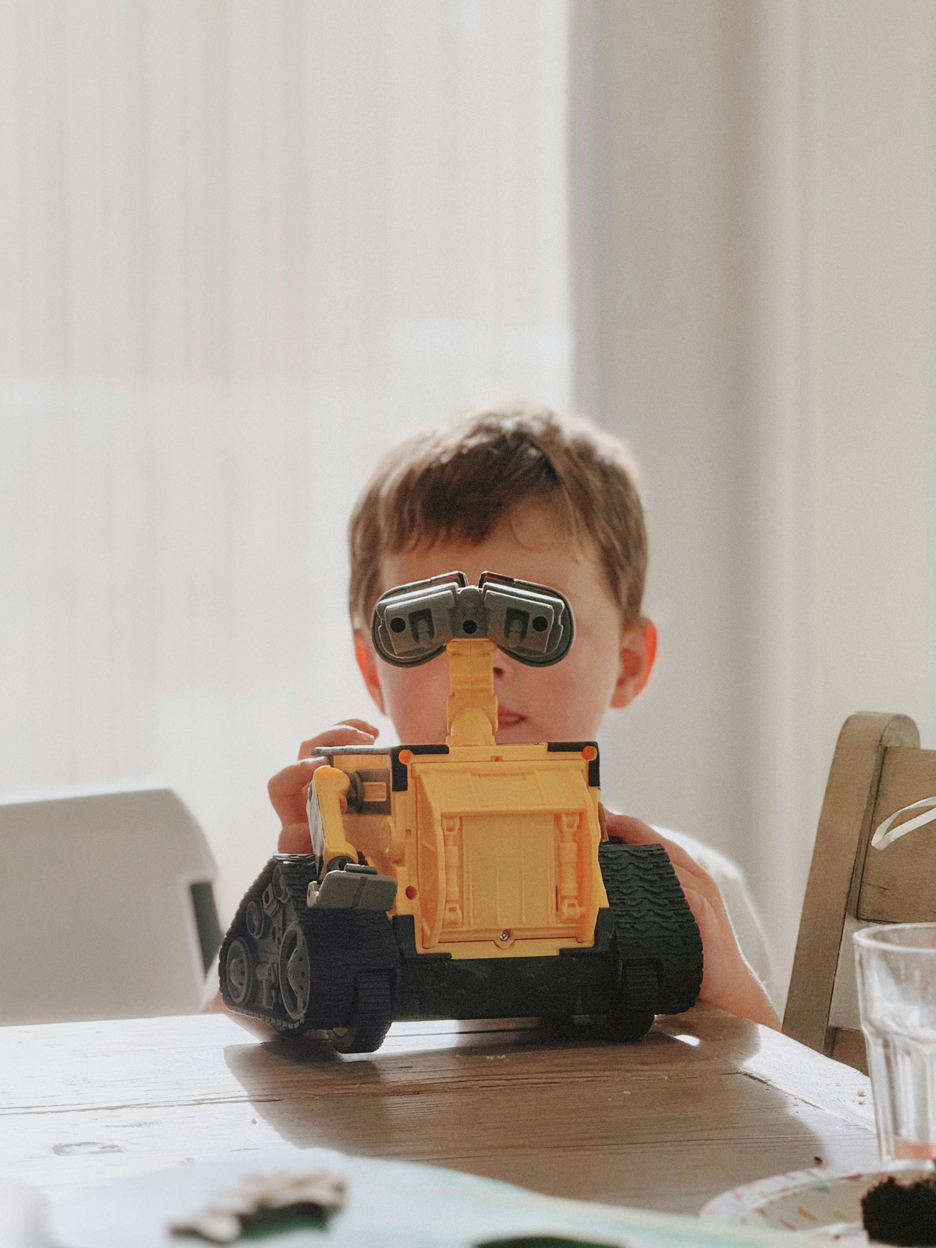 Boy holding a toy robot in front of his face