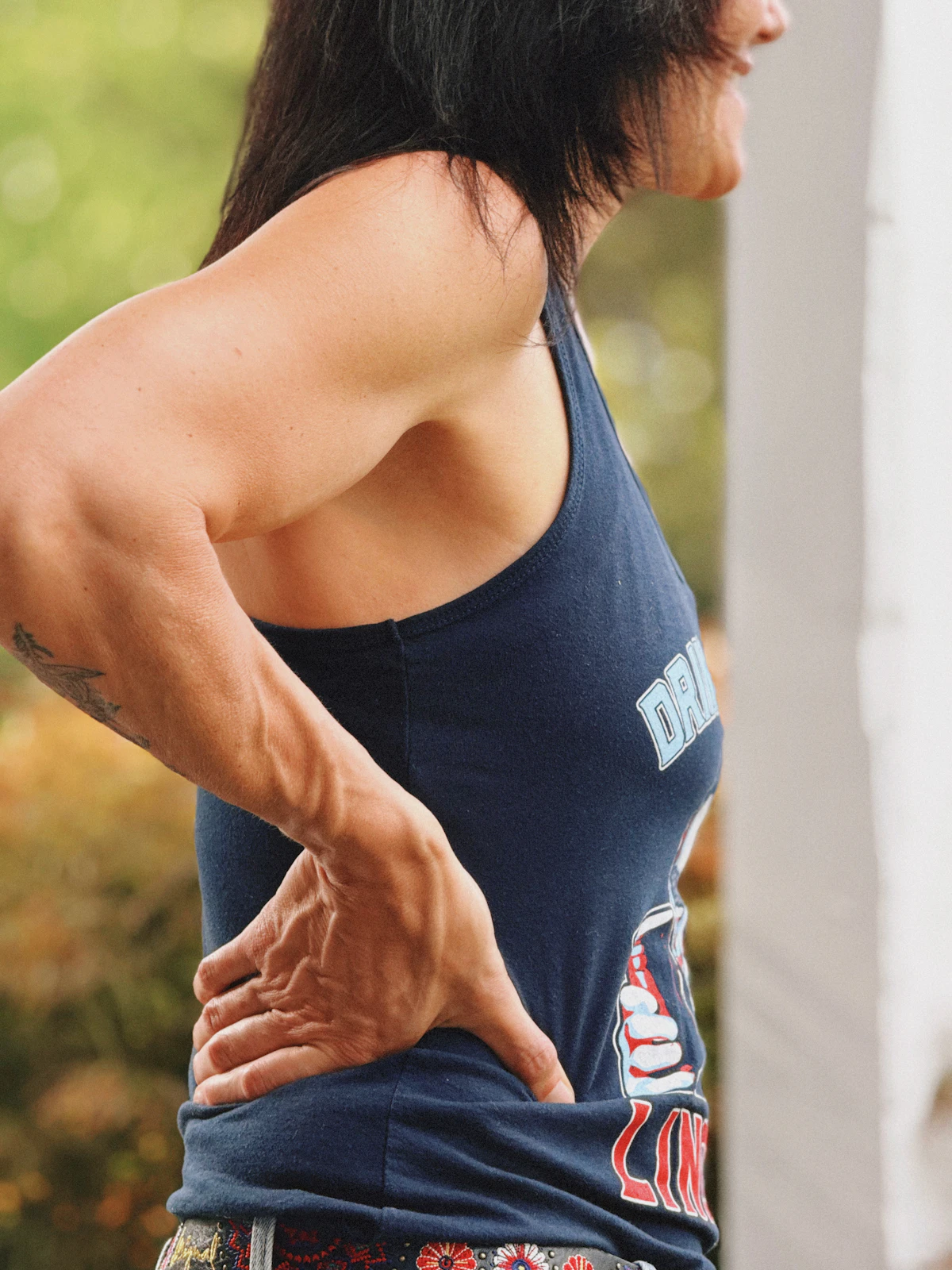 Woman holding her sore lower back suggesting the need for physiotherapy