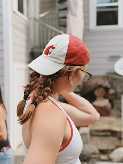 Young woman wearing a red and white baseball cap