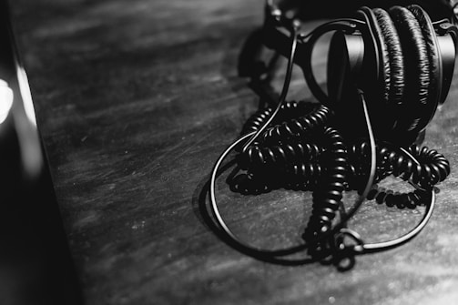 Black and white headphones with coiled cord on table