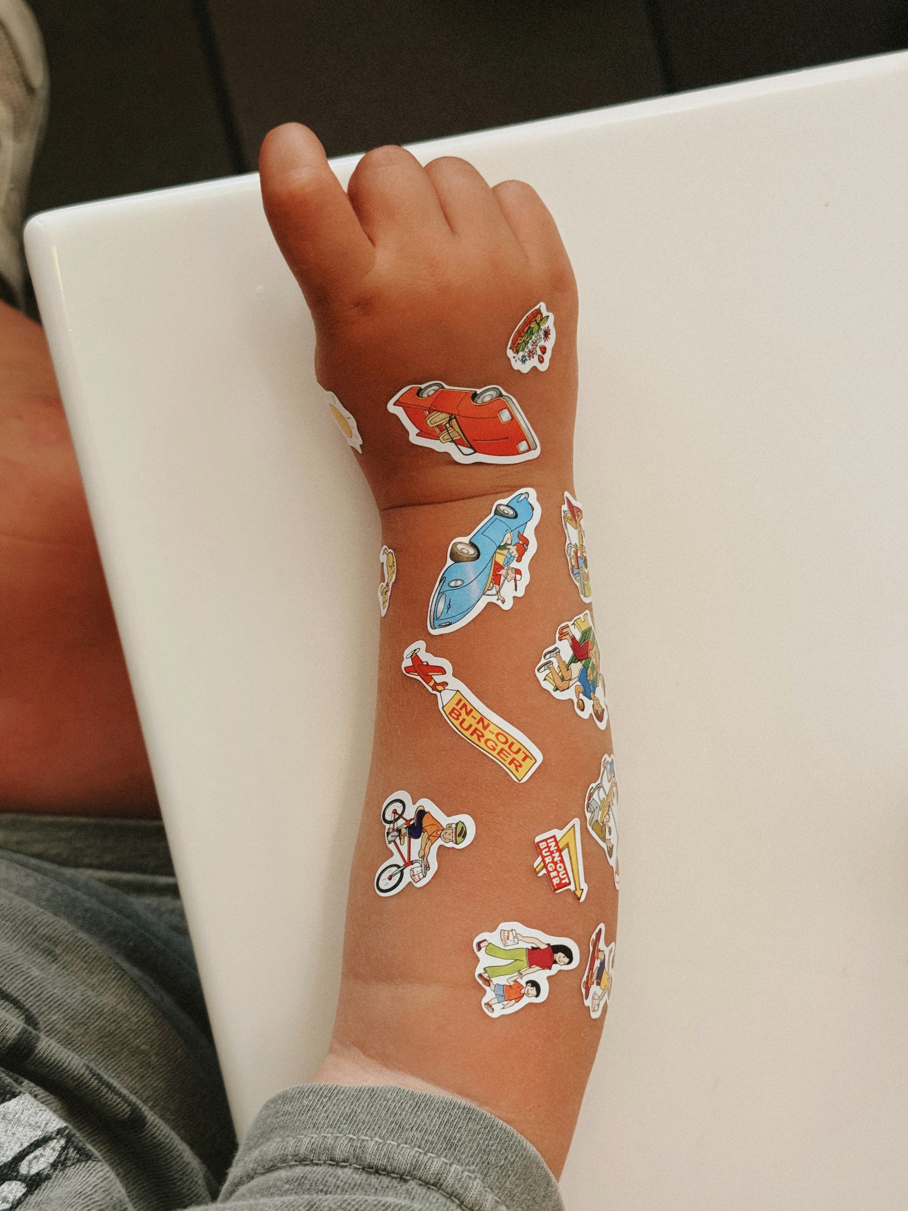 Brazo del niño cubierto de pegatinas de colores