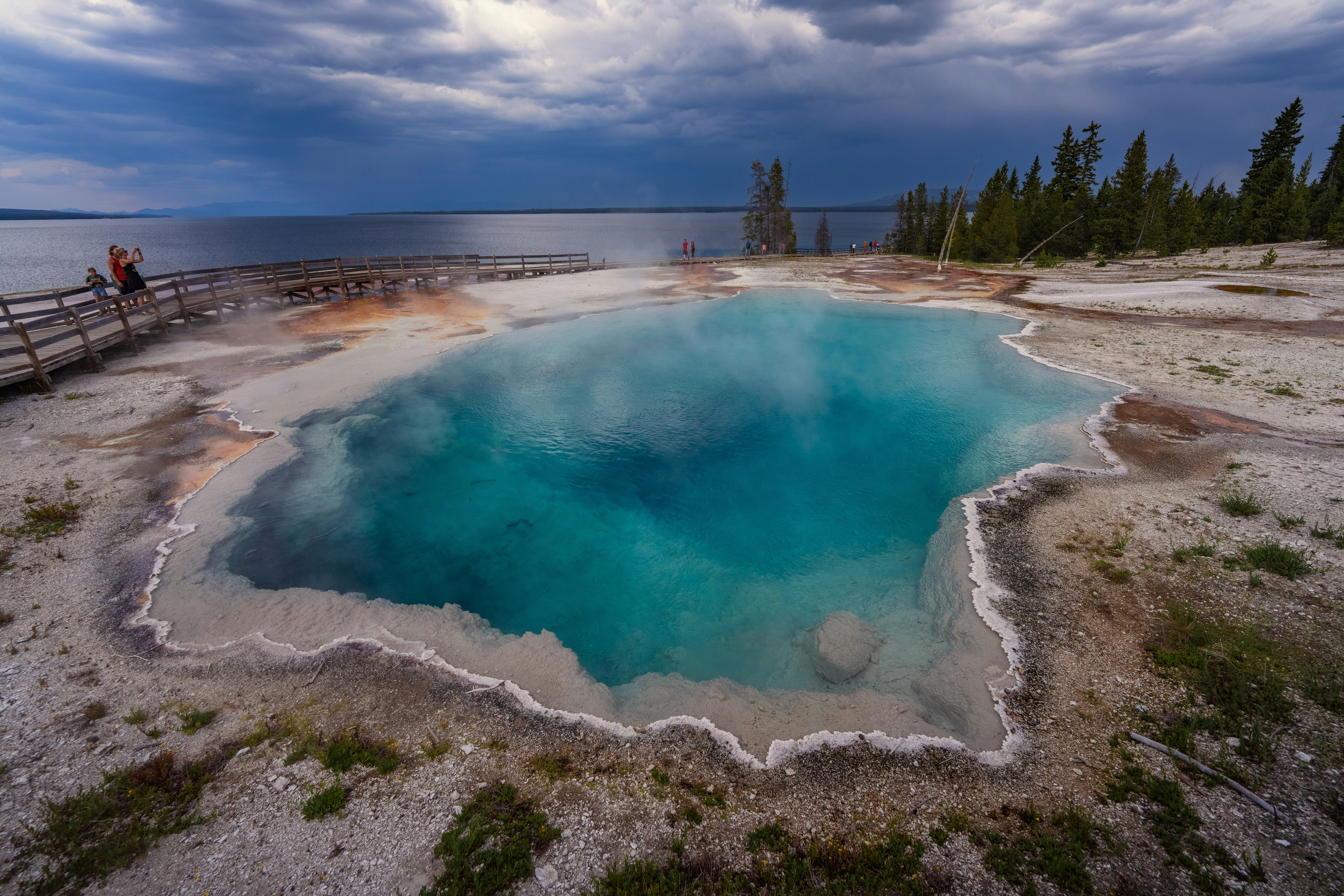 遊歩道のある湖の近くにあるターコイズブルーの温泉プール