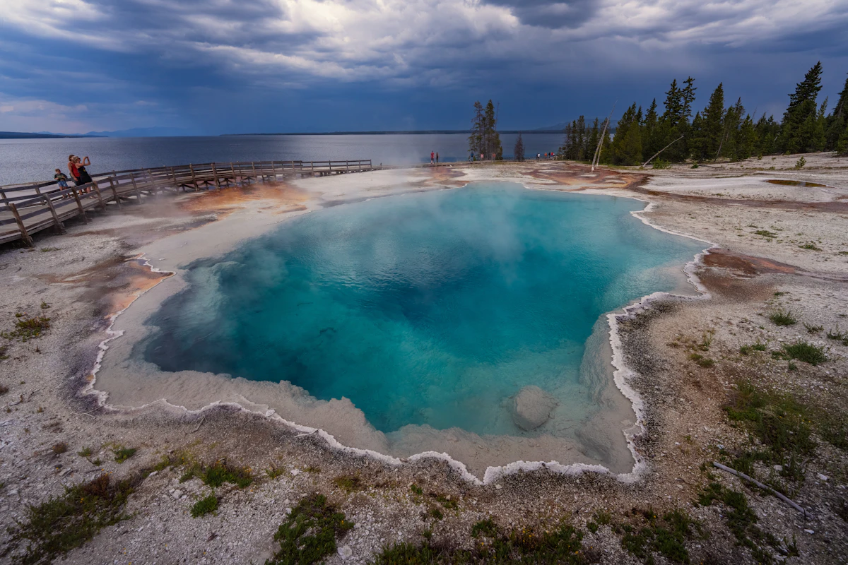 A turquoise hot spring pool with a boardwalk, characteristic of Yellowstone's thermal features