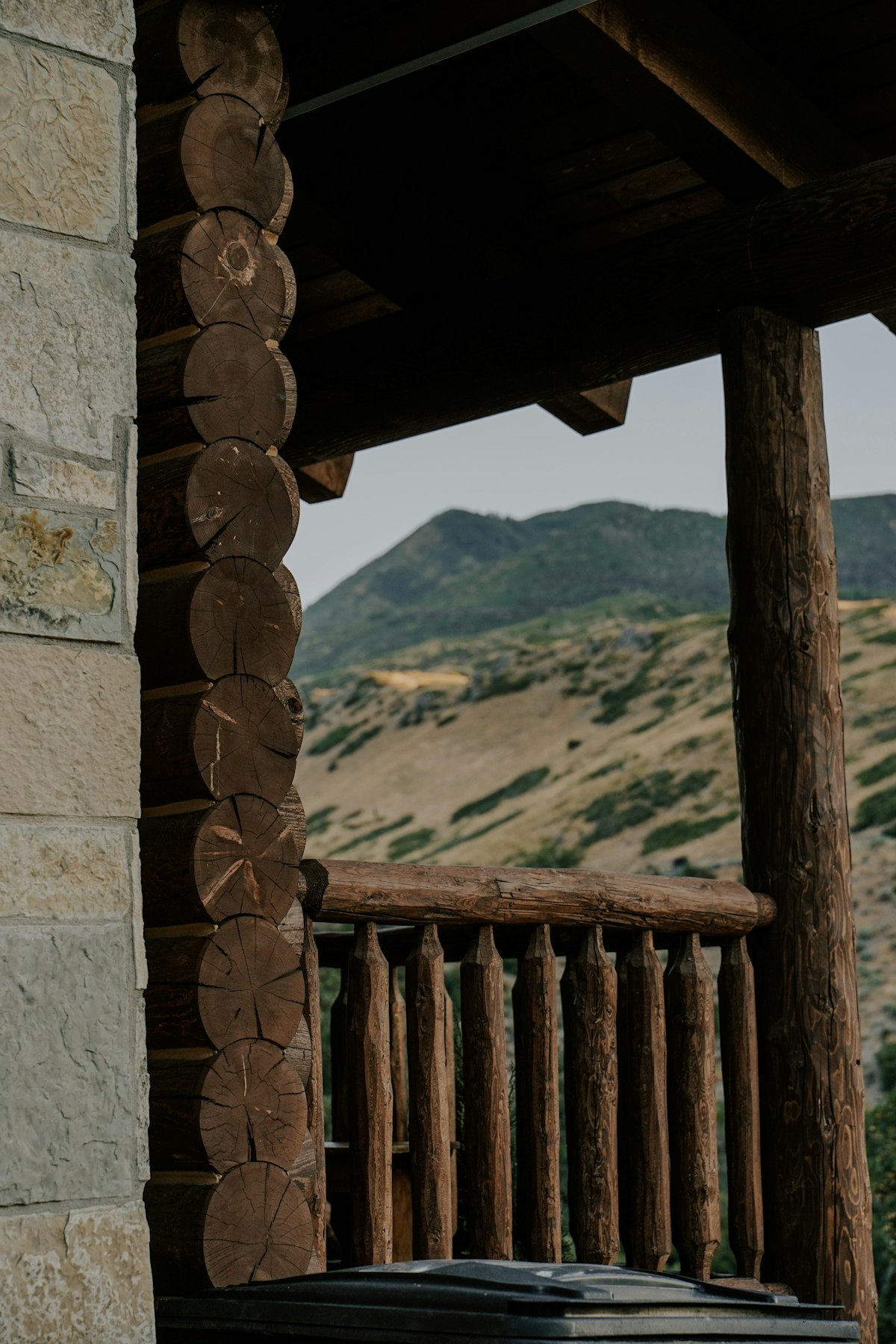 Covered log cabin porch with wooden chairs and mountain view in Flagstaff Arizona