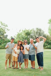 A multi-generational family poses for a group portrait outdoors.
