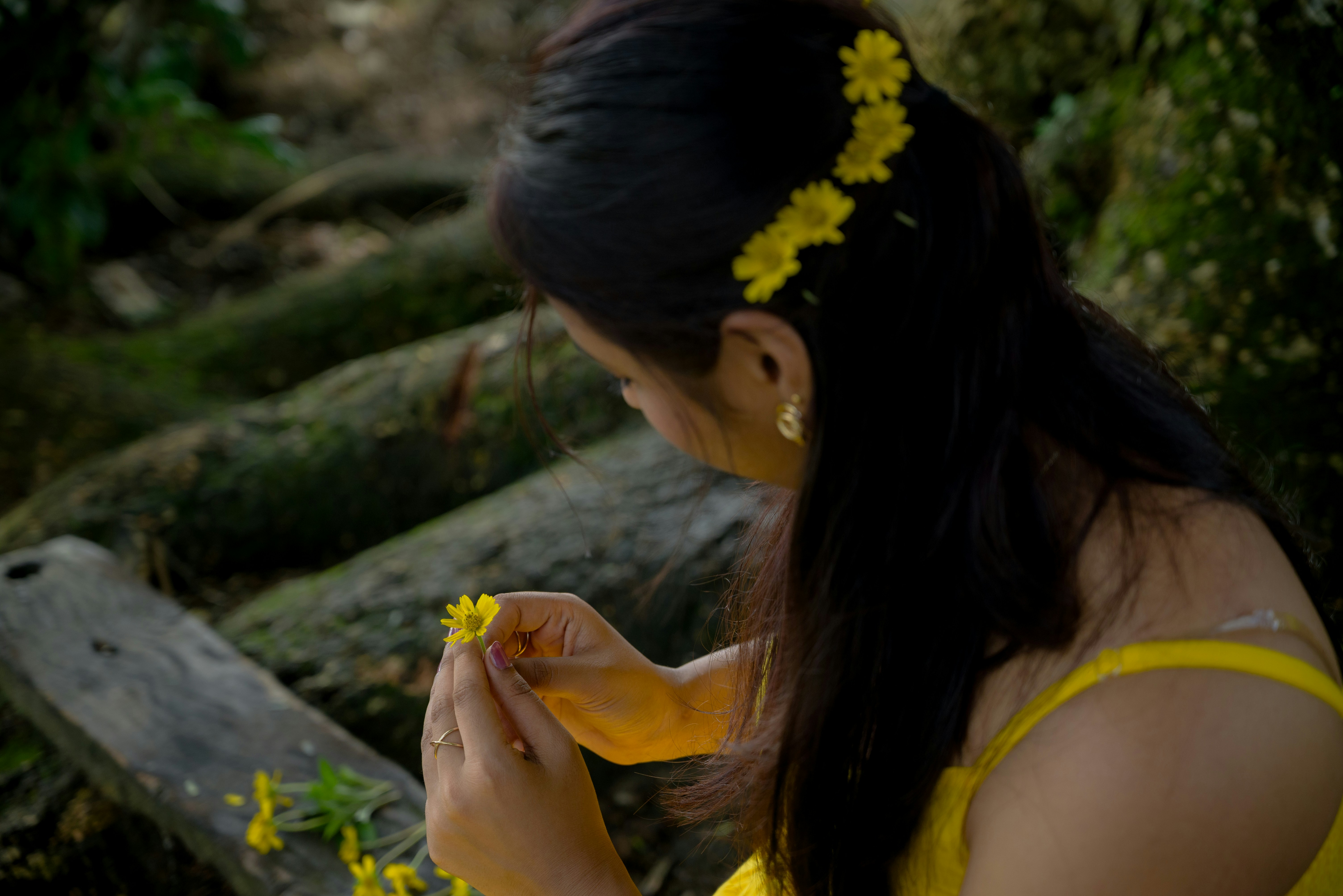 Woman in yellow dress holding a yellow flower