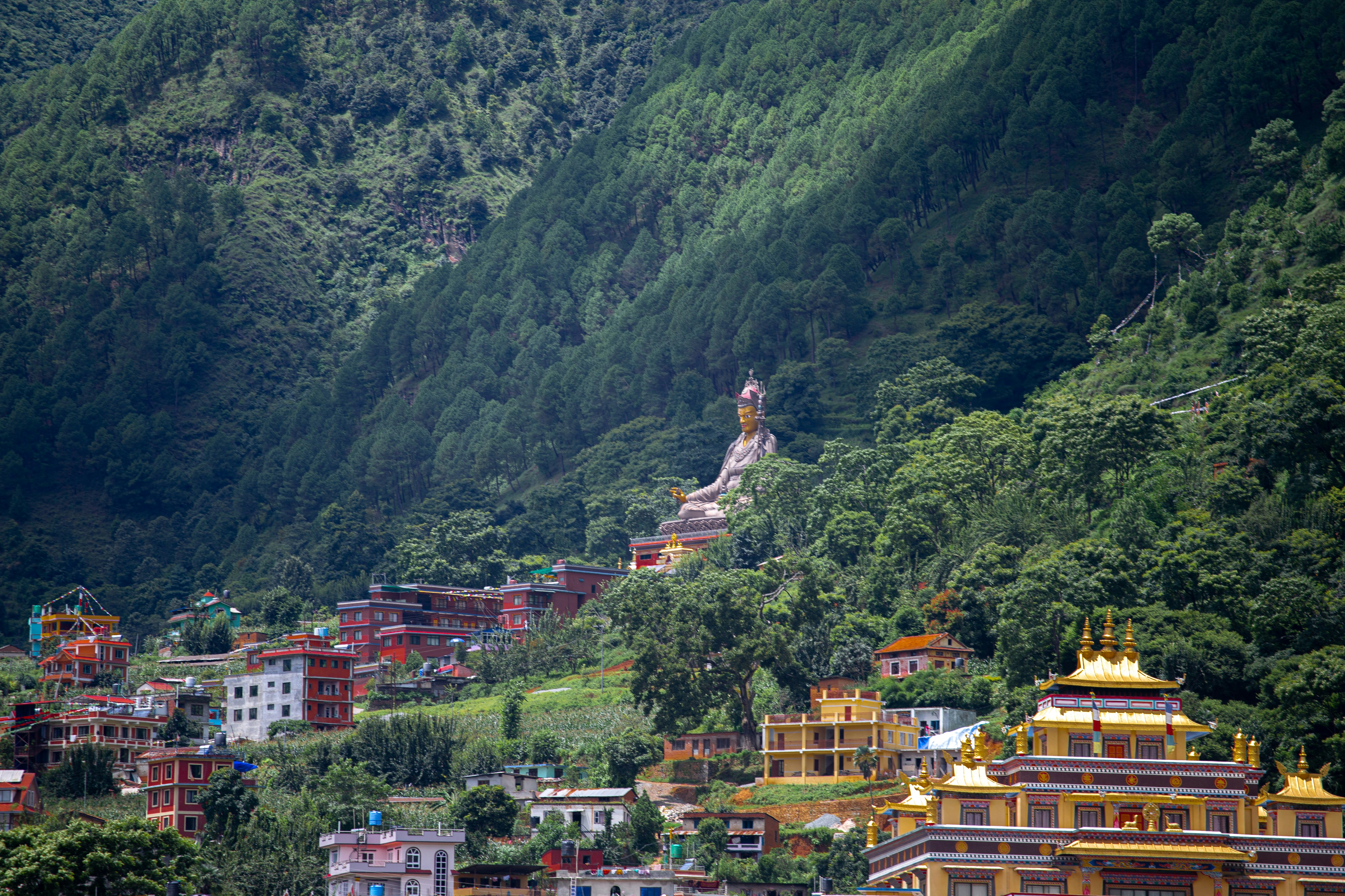 Golden Monastery and Statue Amidst Verdant Hills