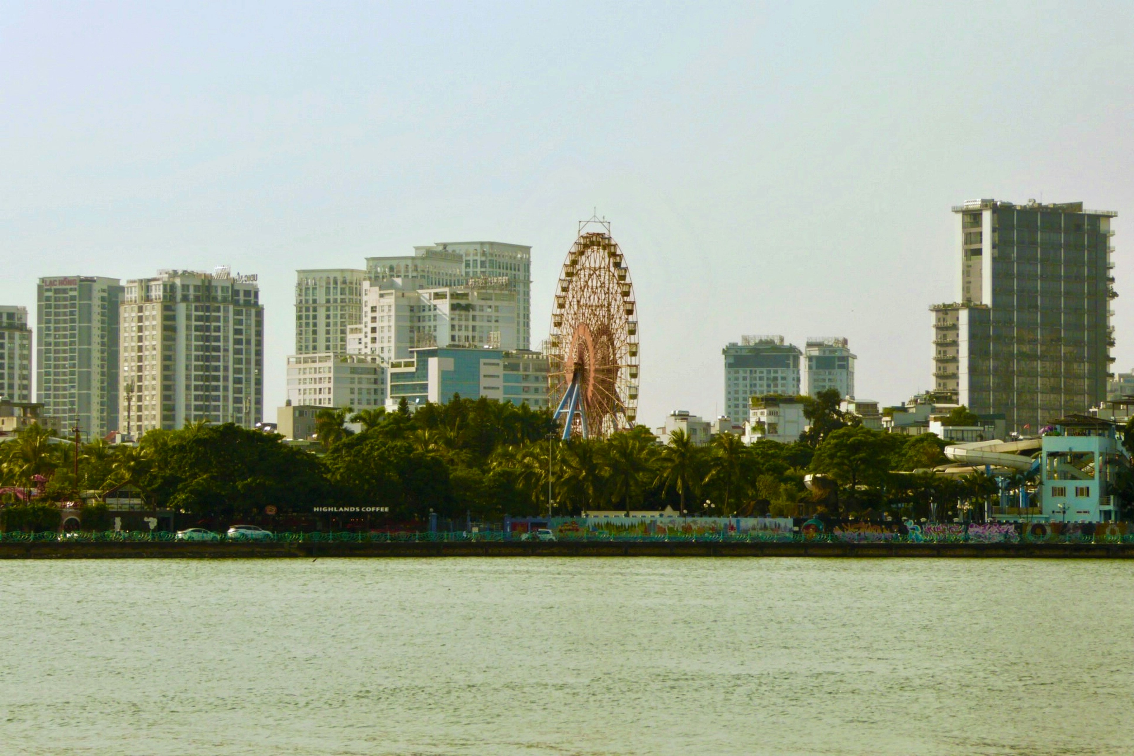 City skyline with tall buildings and ferris wheel.