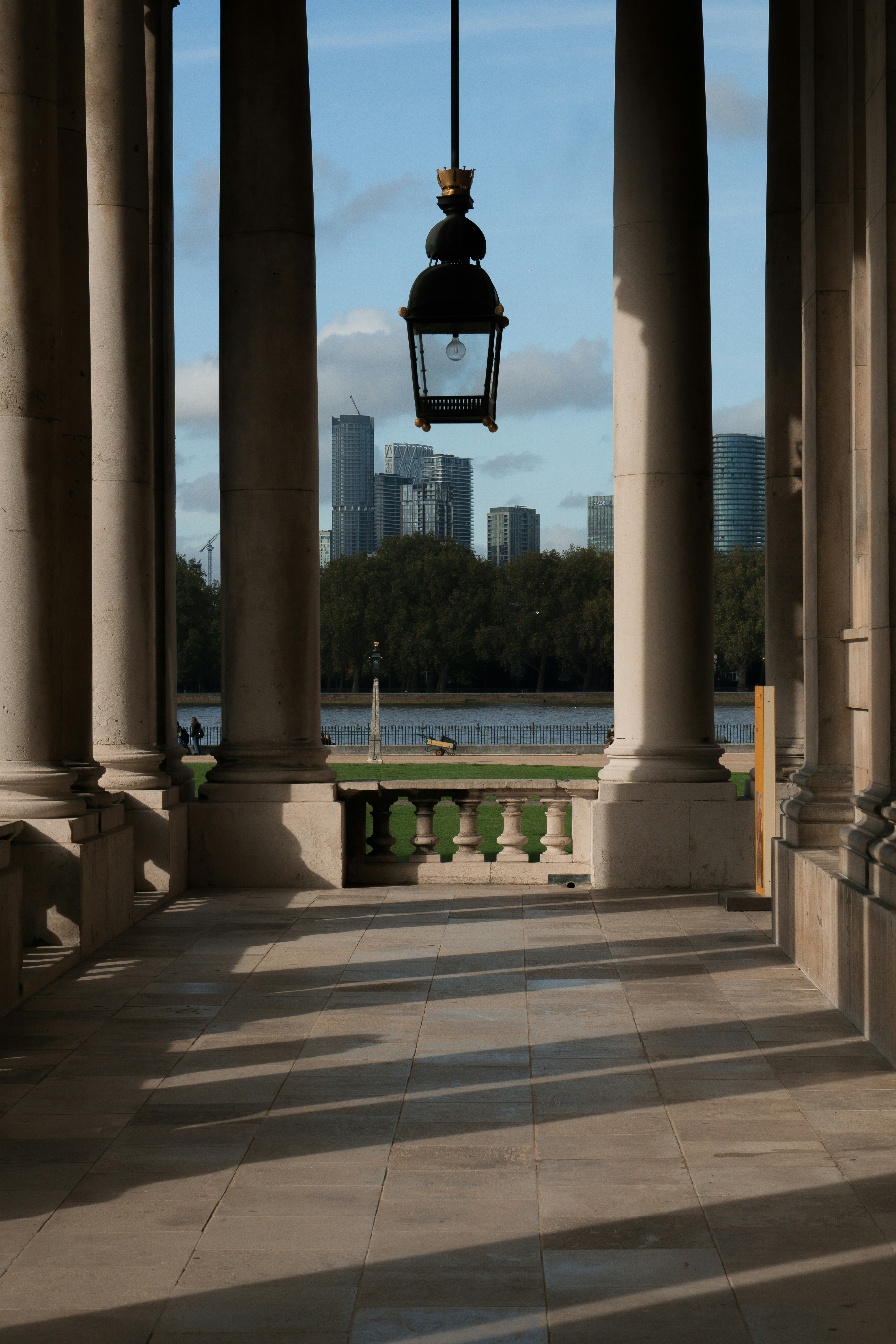 Columns and hanging lantern overlook city skyline