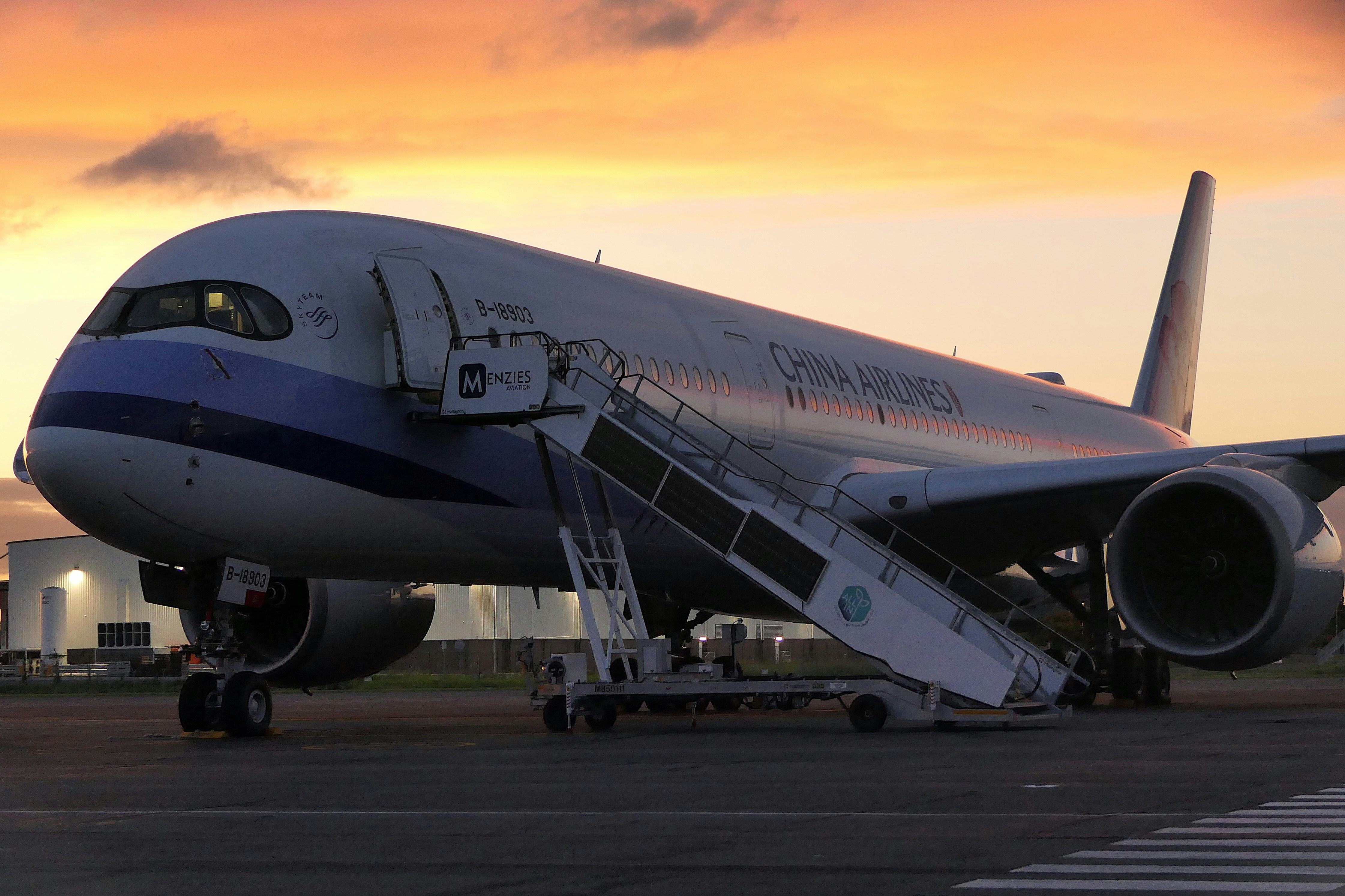 Avião com escadas de embarque ao pôr do sol