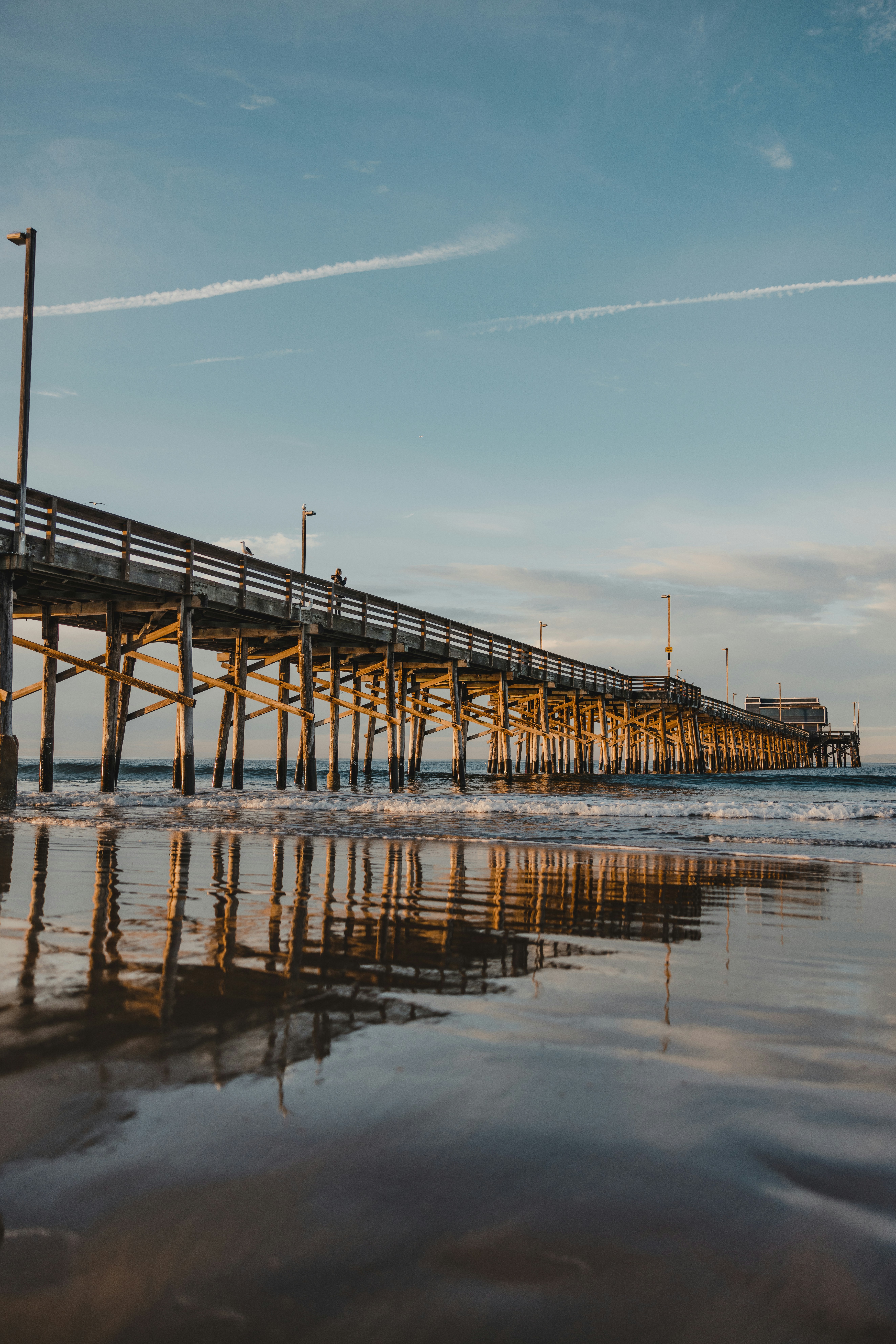 Wooden pier extending over the ocean at sunset
