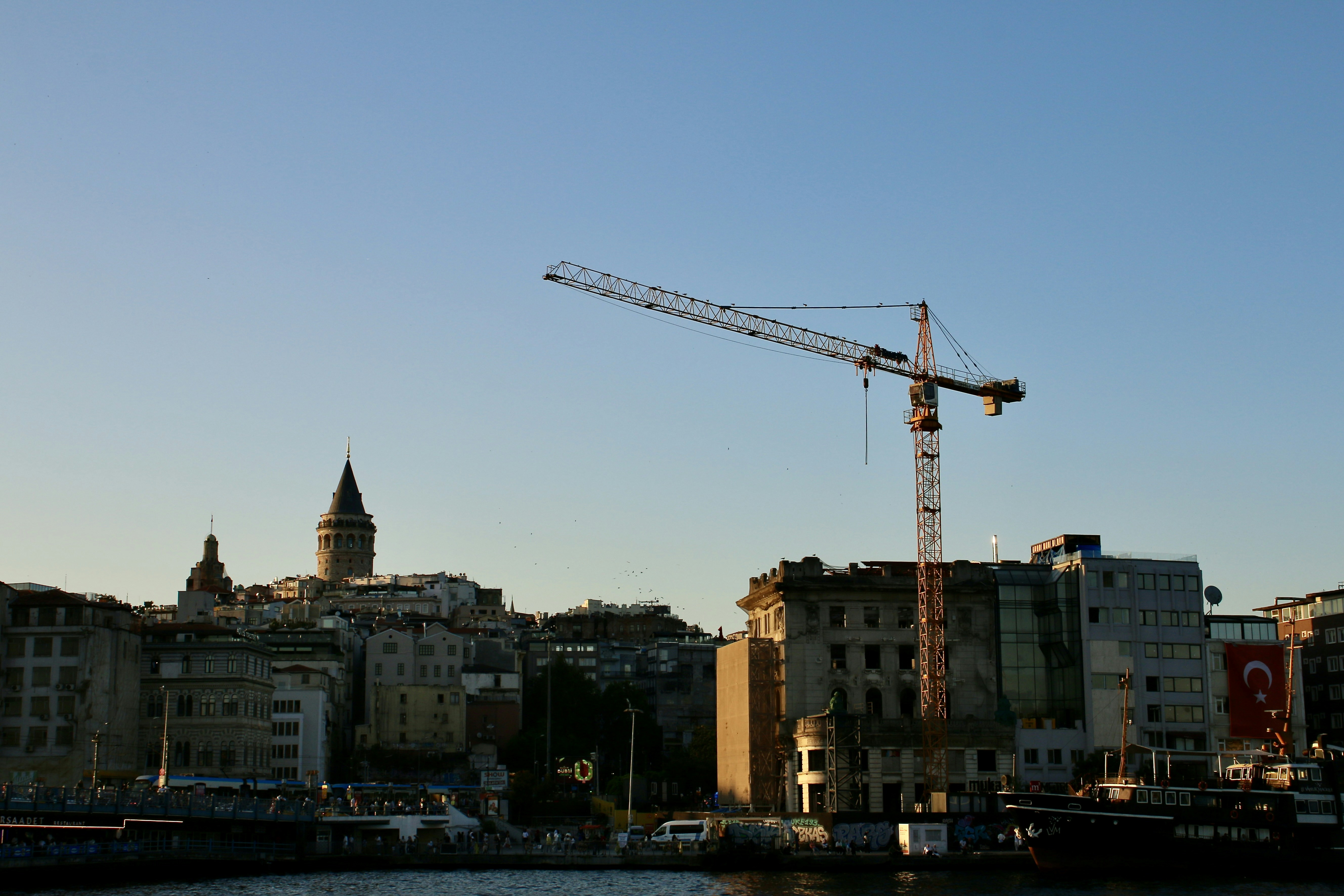 City skyline with a crane against a clear blue sky
