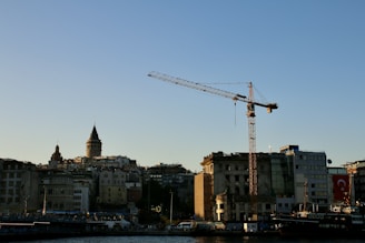 City skyline with a crane against a clear blue sky