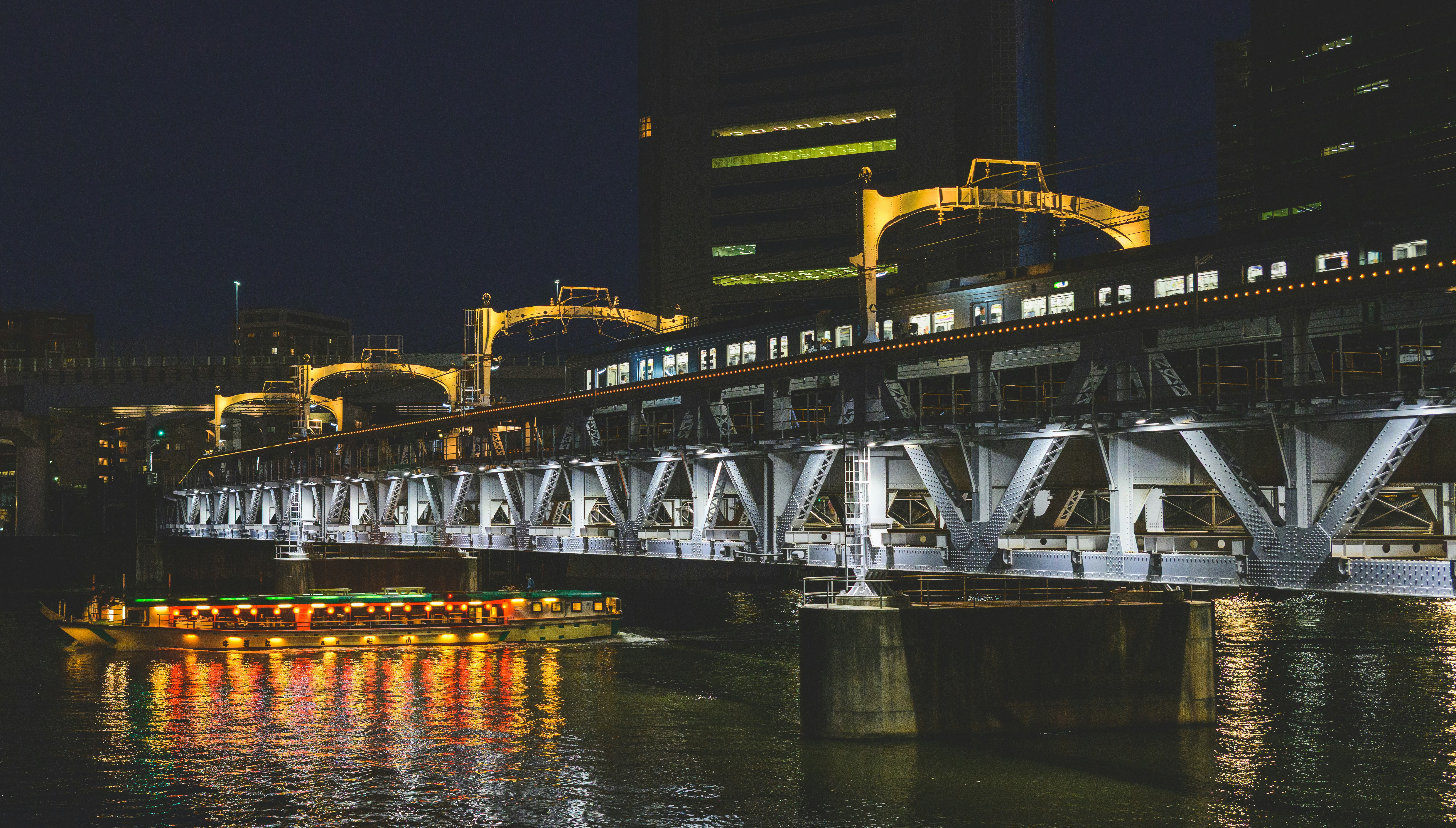 Illuminated bridge over water at night