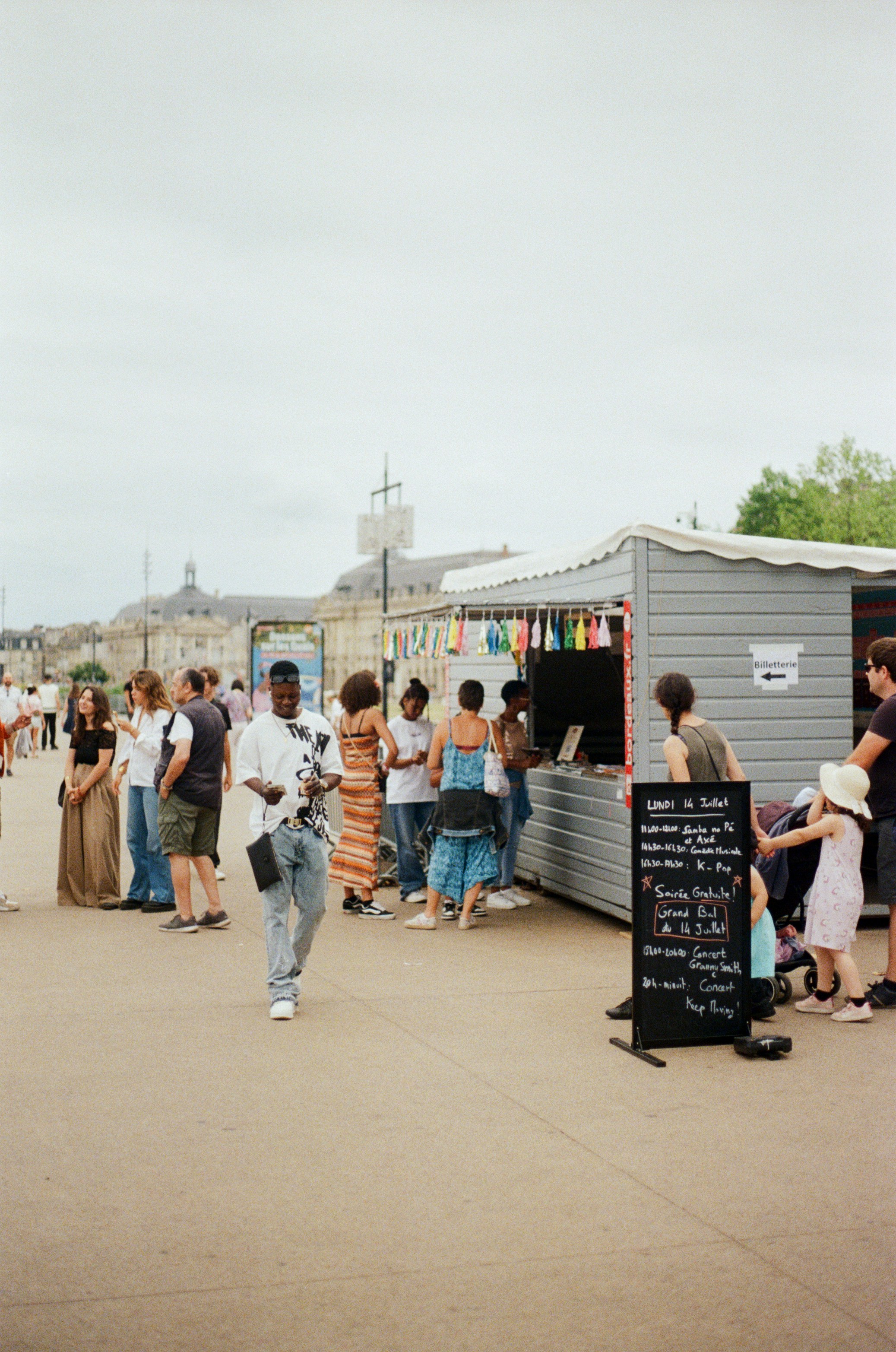 People gathered at outdoor food stalls on a cloudy day