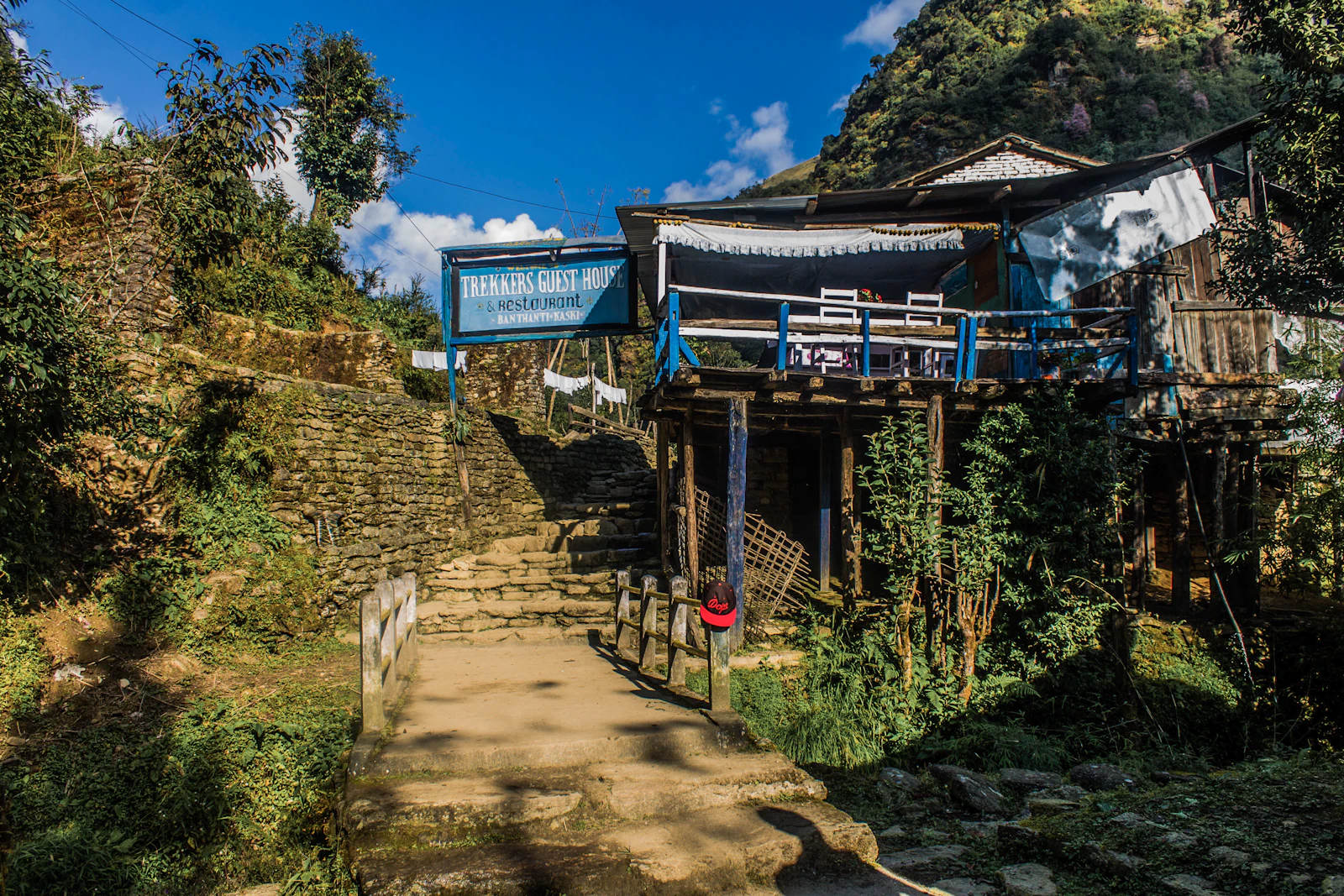 Вывеска «Trekkers Guest House & Restaurant» у горного лоджа на треккинговой тропе в Непале