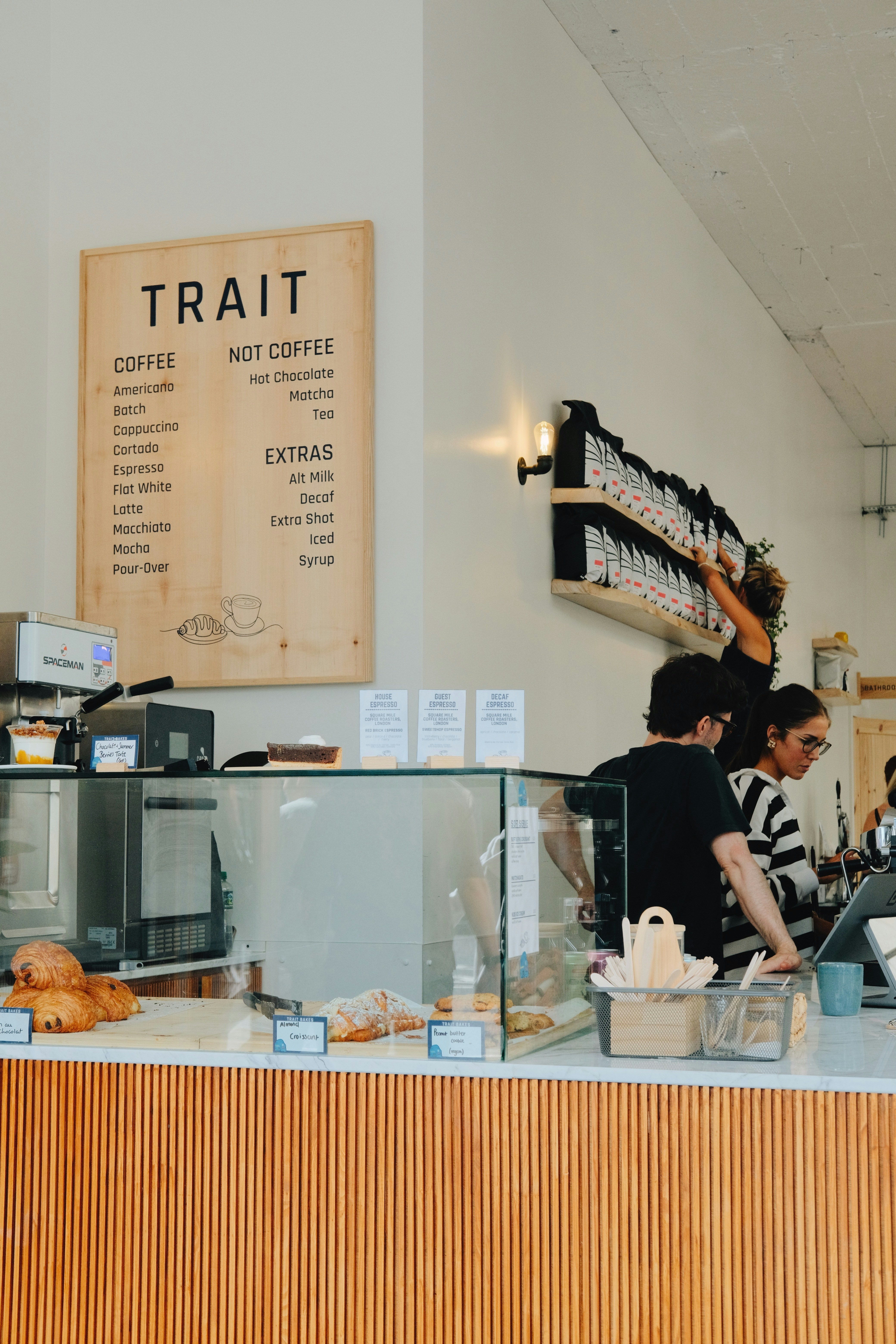 People behind a counter at a coffee shop.