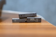 Two small electronic devices stacked on a wooden surface.