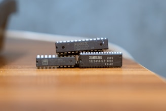 Two small electronic devices stacked on a wooden surface.