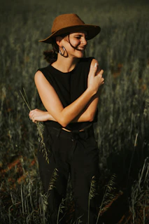 Woman wearing hat in a field of tall grass