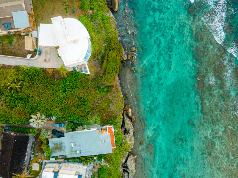 Aerial view of coastal homes beside turquoise water
