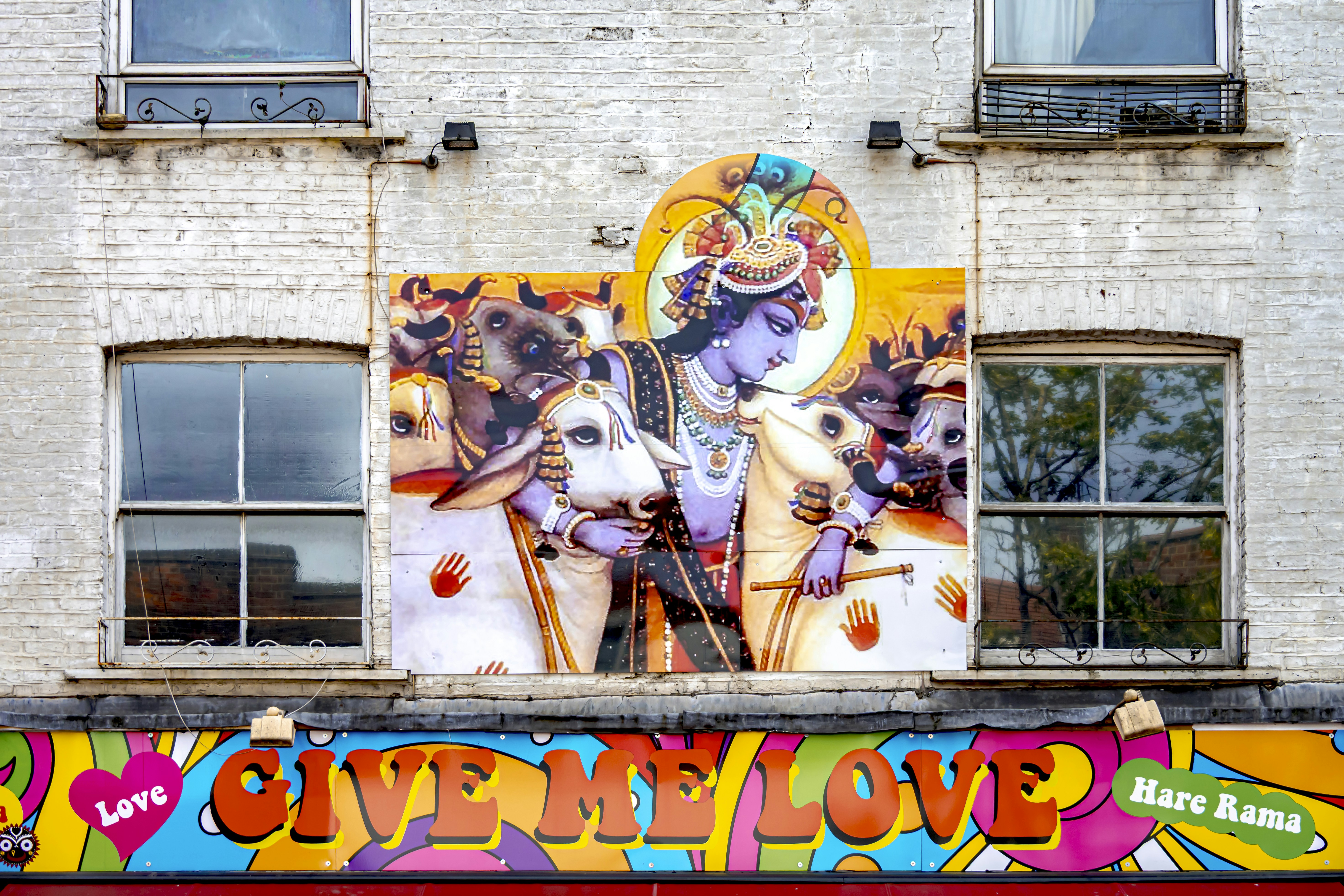 Building facade with vibrant mural and colorful signage.