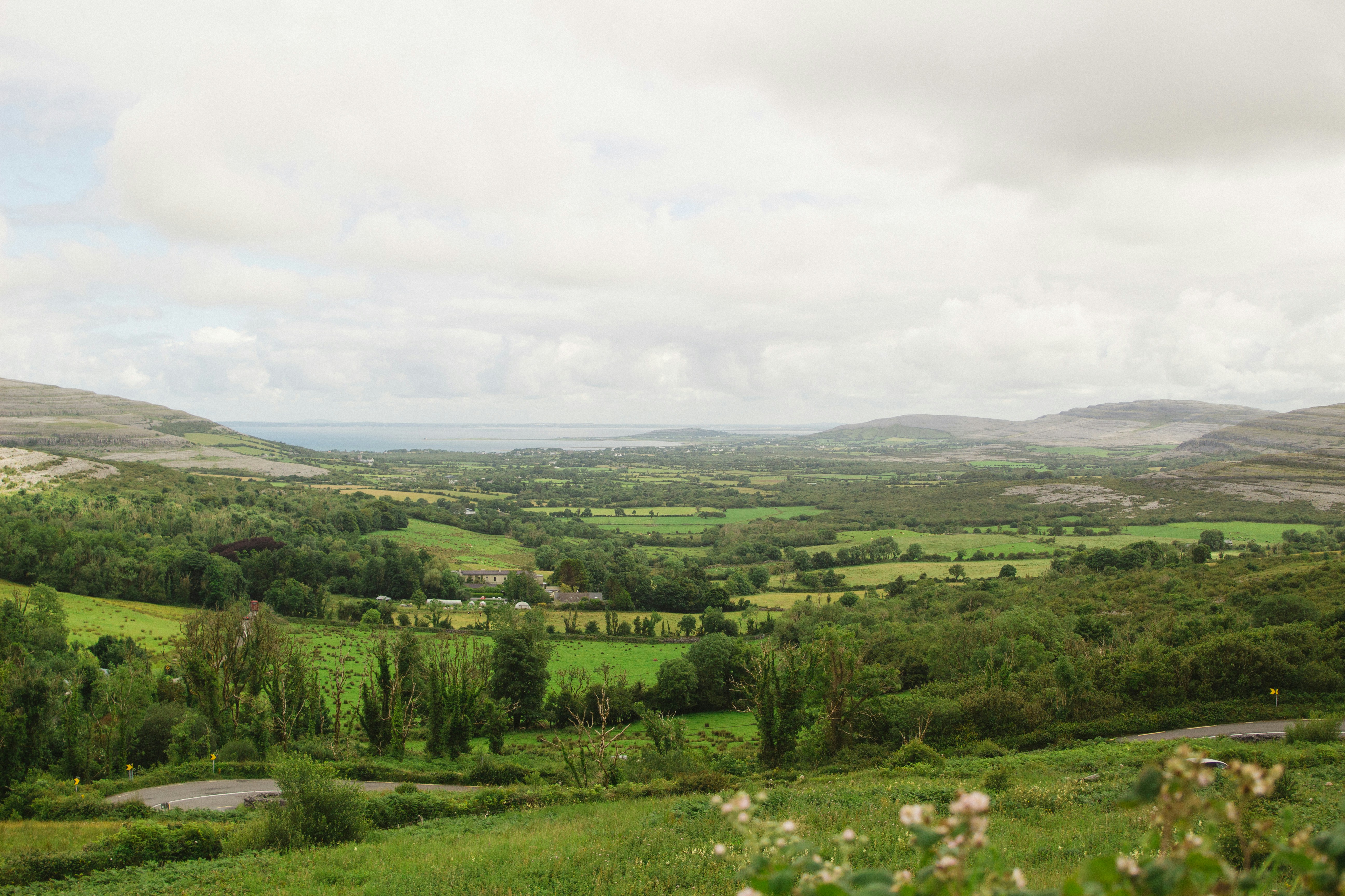 Des collines verdoyantes sous un ciel nuageux