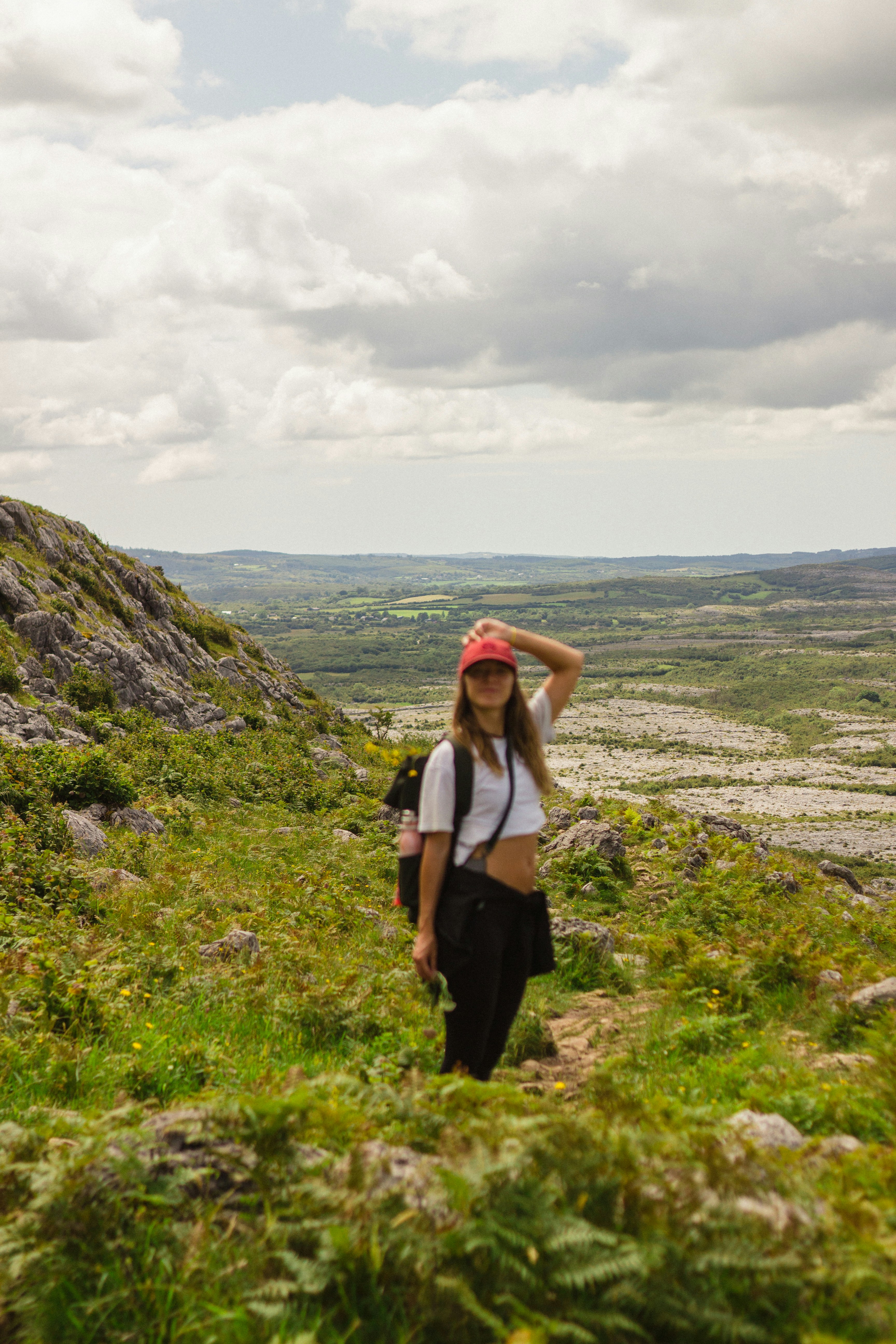 Une jeune femme faisant de la randonnée sur une colline herbeuse