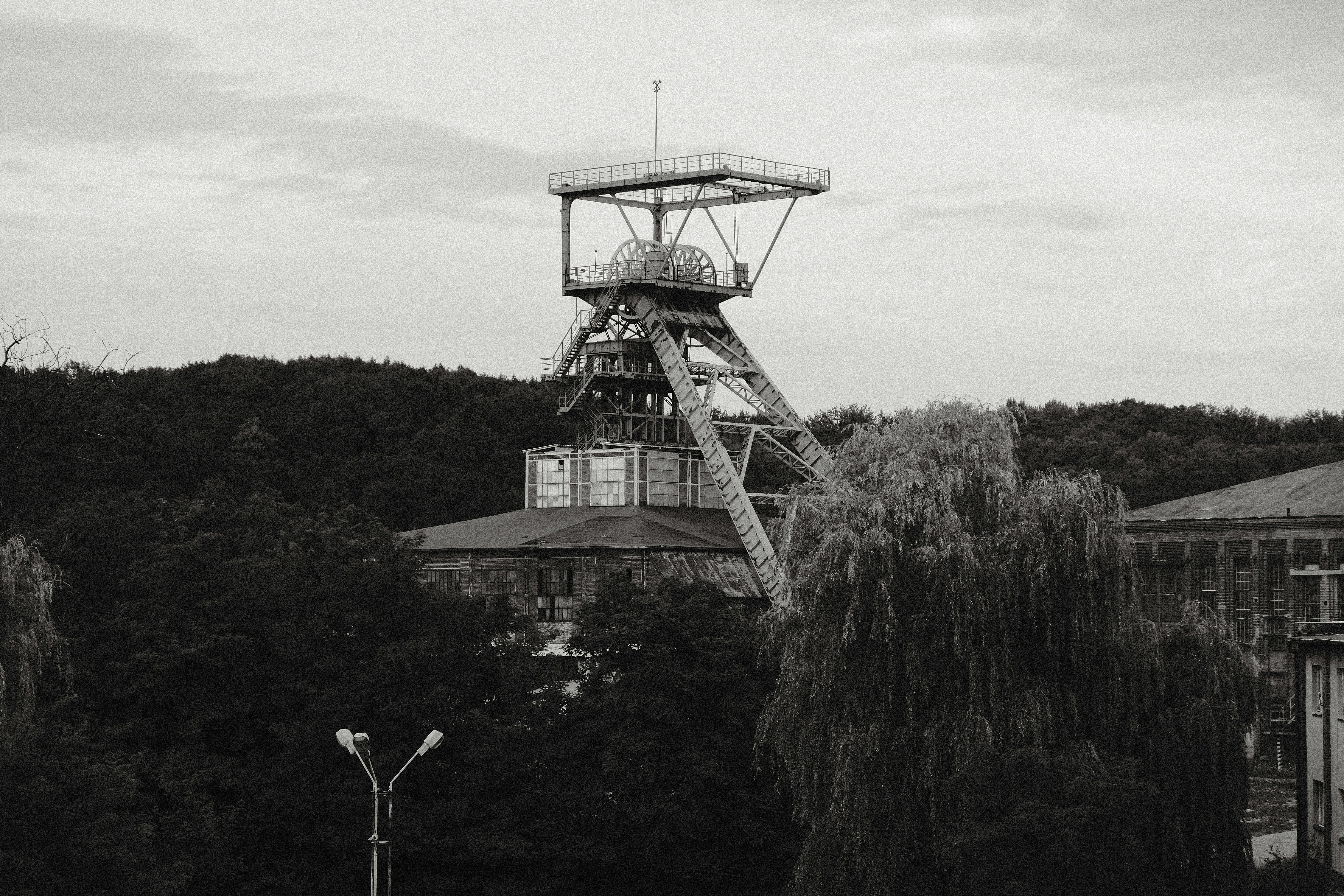 Industrial mining tower with trees and overcast sky