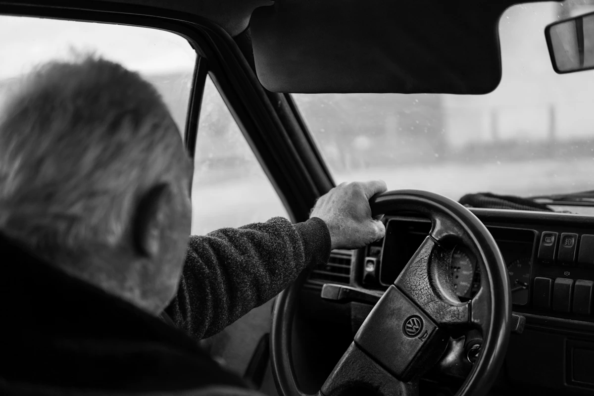 Elderly man driving a car, focused and calm behind the wheel