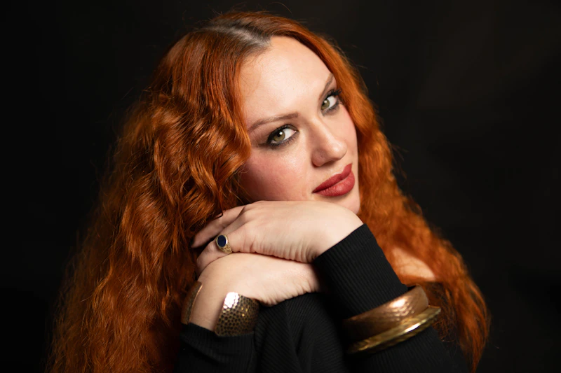 mujer radiante con cabello rojo y accesorios