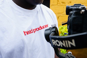 Man in white t-shirt with red text and camera rig