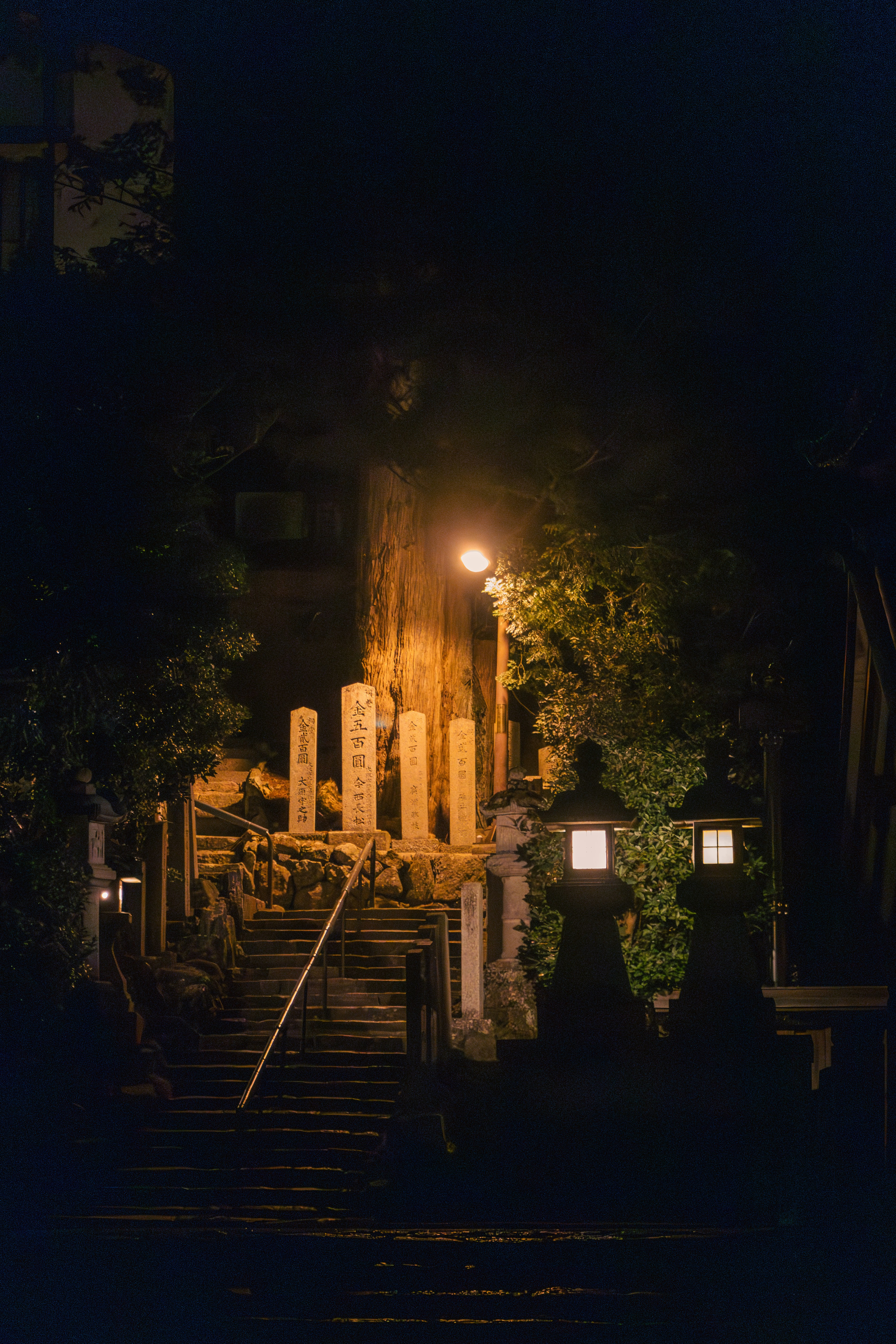 Stone steps leading up to illuminated structures at night