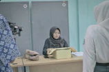 Woman in hijab at desk with papers