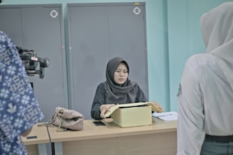 Woman in hijab at desk with papers