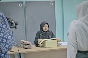 Woman in hijab at desk with papers